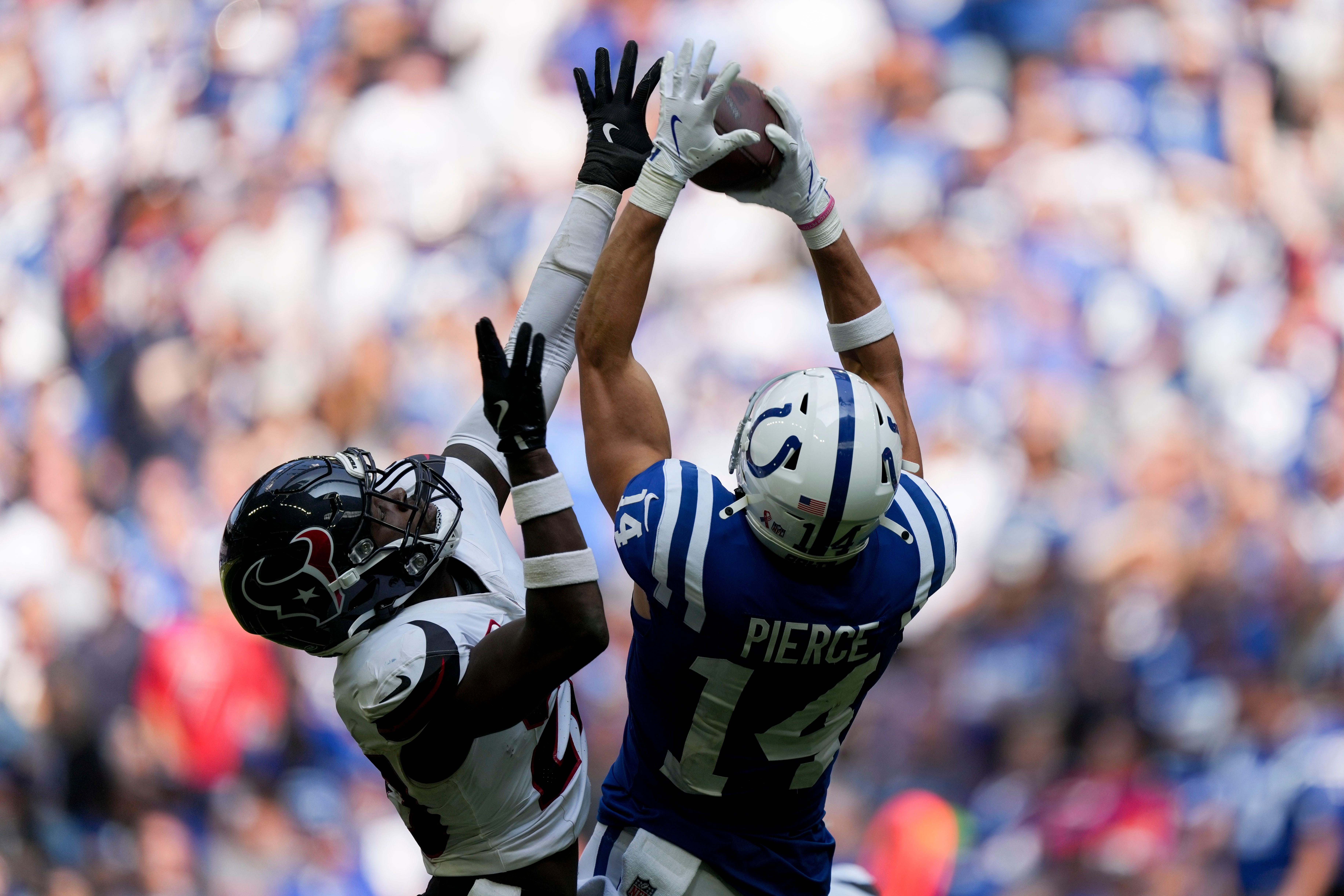 Indianapolis Colts wide receiver Alec Pierce (14) pulls in a pass while being guarded by a Houston Texans defender Sunday, Sept. 8, 2024, during a game against the Houston Texans at Lucas Oil Stadium in Indianapolis.