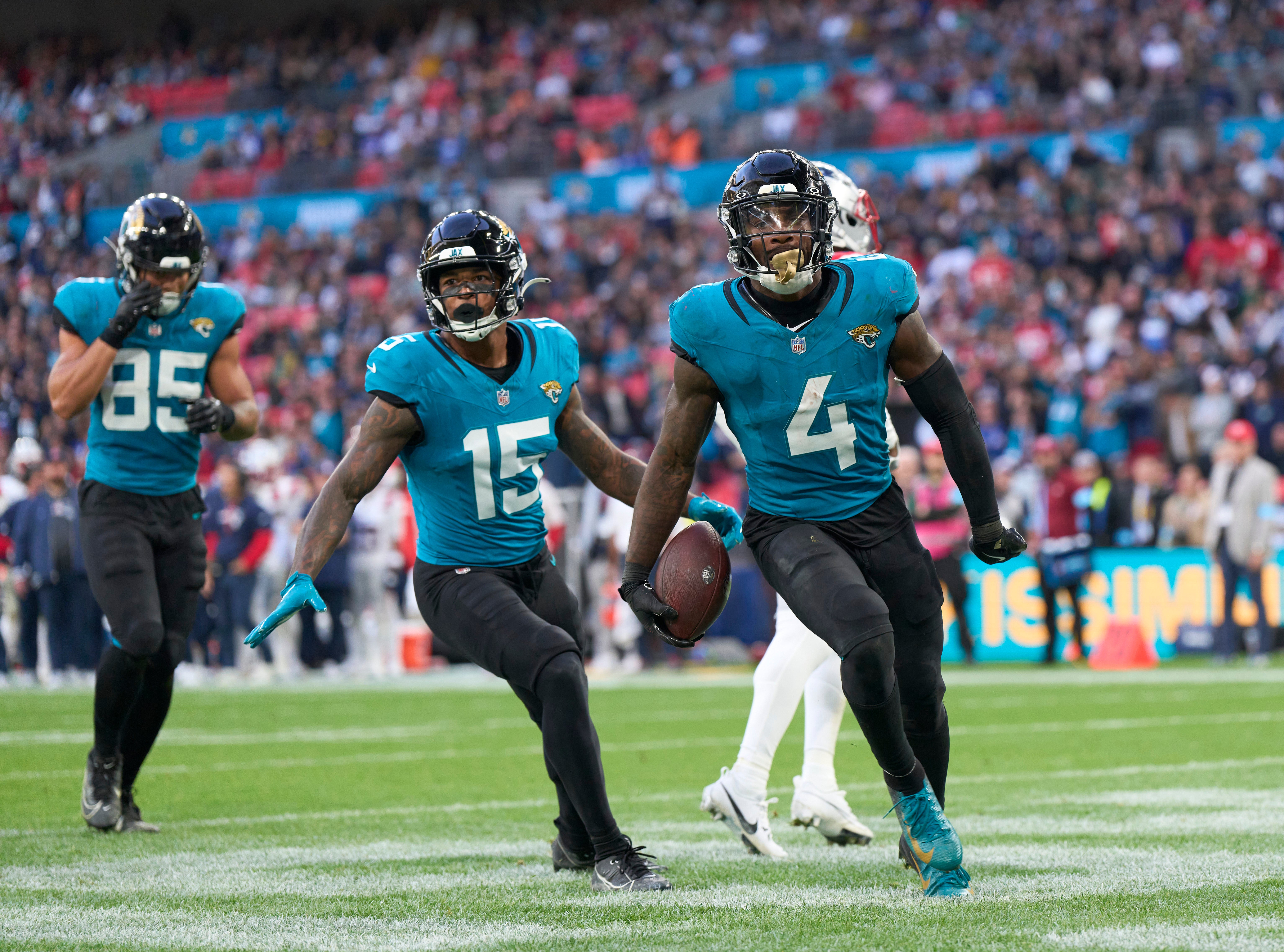 Oct 20, 2024; London, United Kingdom; Jacksonville Jaguars running back Tank Bigsby (4) celebrates a touchdown with teammates Jacksonville Jaguars wide receiver Tim Jones (15) and Jacksonville Jaguars tight end Brenton Strange (85) in the second half during an NFL International Series game at Wembley Stadium.
