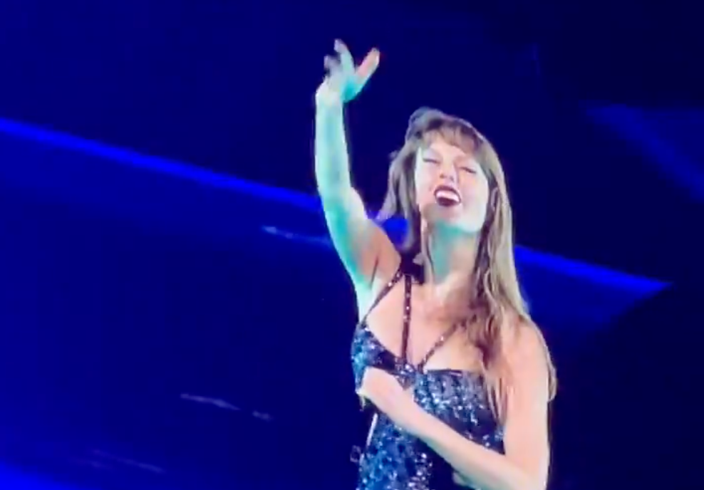 Taylor Swift pretends to throw a football during the first night of her Eras Tour show in New Orleans.