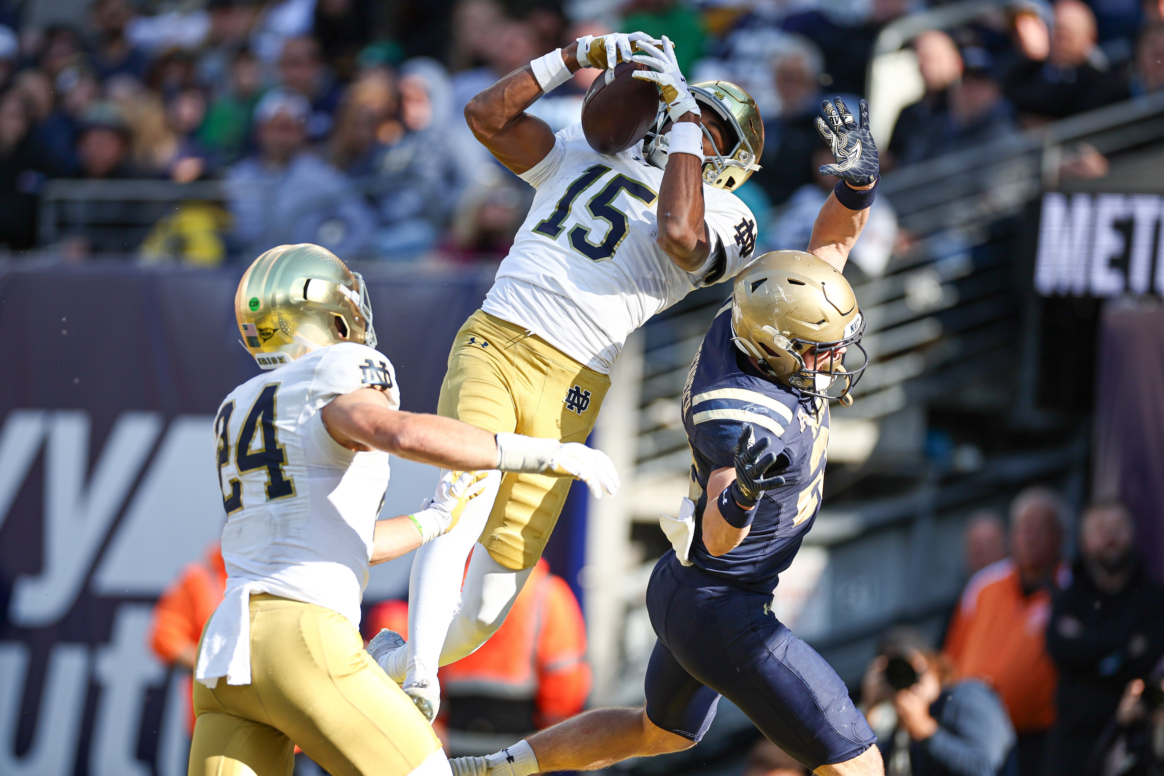 Notre Dame Fighting Irish cornerback Leonard Moore (15) intercepts a pass intended for Navy Midshipmen running back Eli Heidenreich (22) in front of linebacker Jack Kiser (24) during the second half at MetLife Stadium.