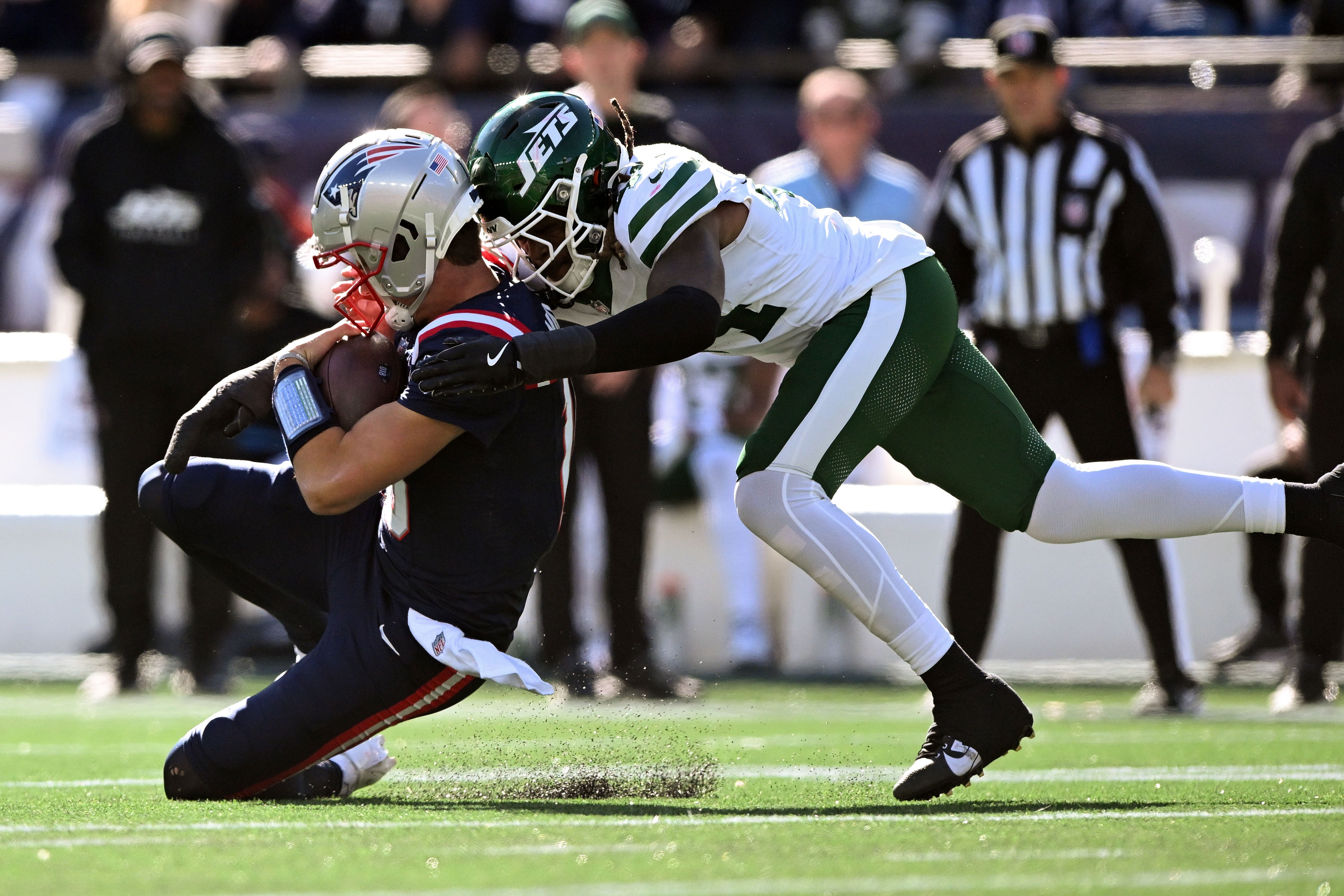 Oct 27, 2024; Foxborough, Massachusetts, USA; New England Patriots quarterback Drake Maye (10) is tackled by New York Jets linebacker Jamien Sherwood (44) during the first half at Gillette Stadium.