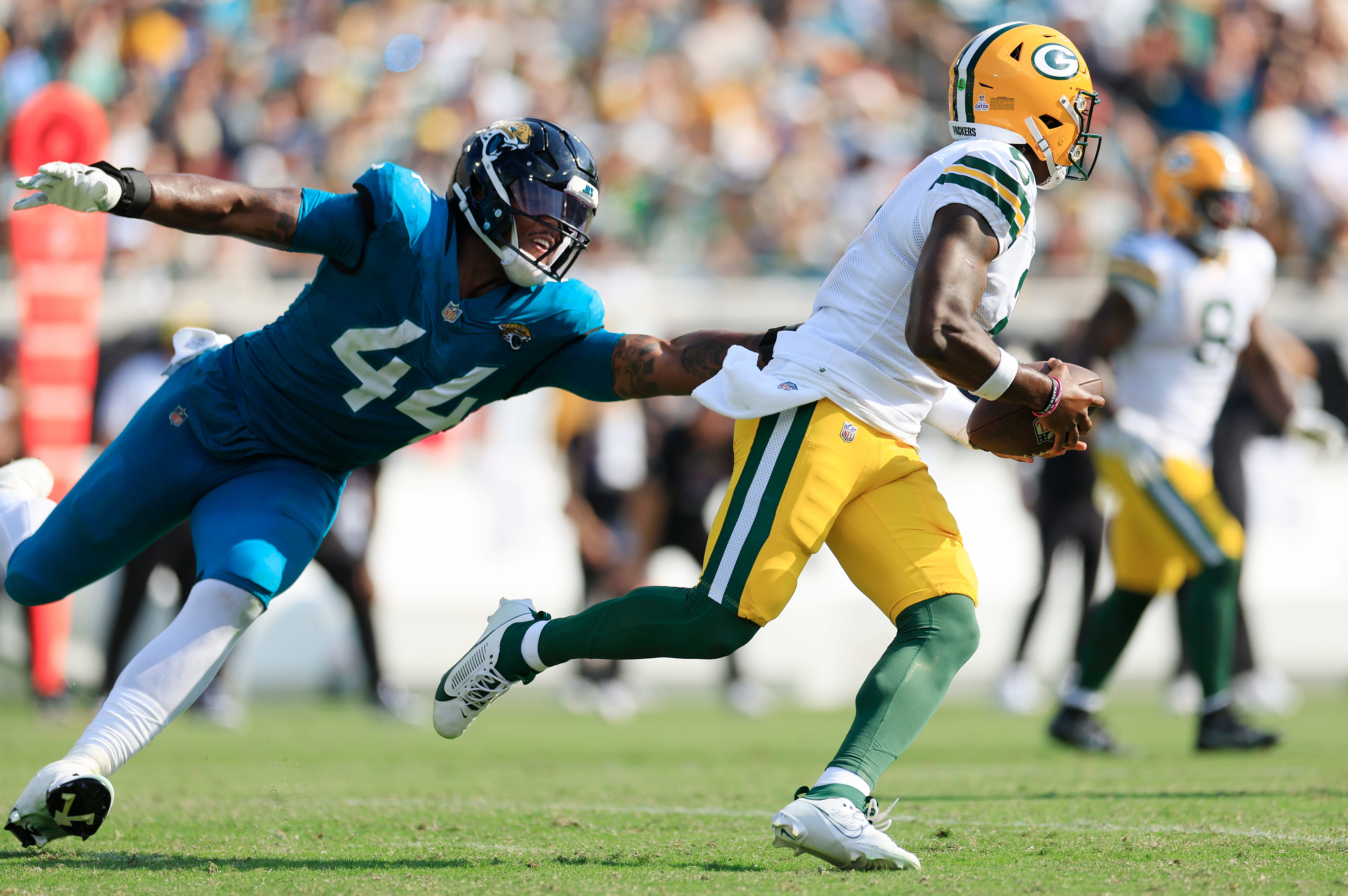 Jacksonville Jaguars defensive end Travon Walker (44) can’t stop Green Bay Packers quarterback Malik Willis (2) during the third quarter of an NFL football matchup Sunday, Oct. 27, 2024 at EverBank Stadium in Jacksonville, Fla. The Packers edged the Jaguars 30-27 on a last-second field goal.