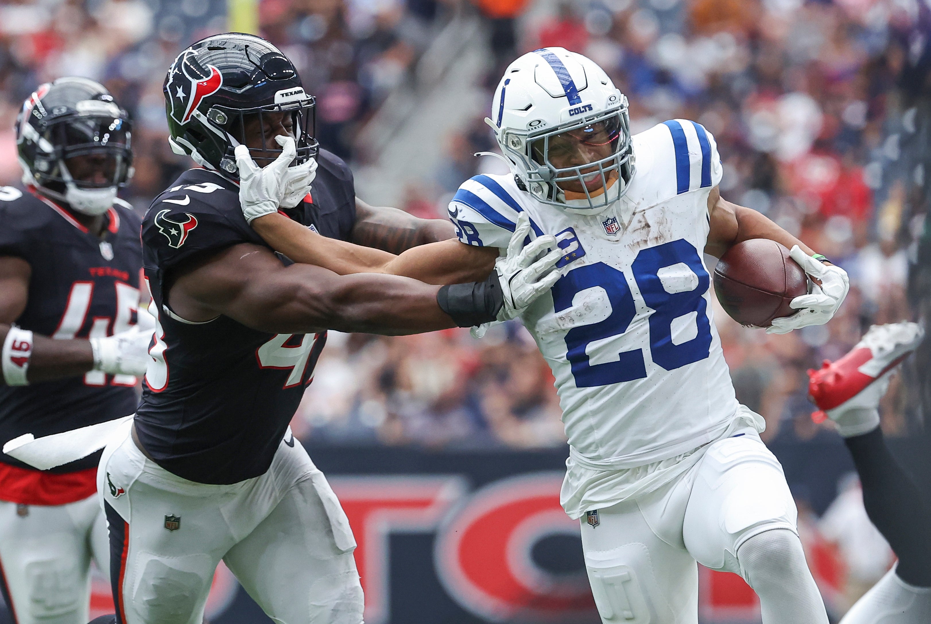 back Jonathan Taylor (28) runs with the ball as Houston Texans linebacker Neville Hewitt (43) attempts to make a tackle during the third quarter at NRG Stadium.