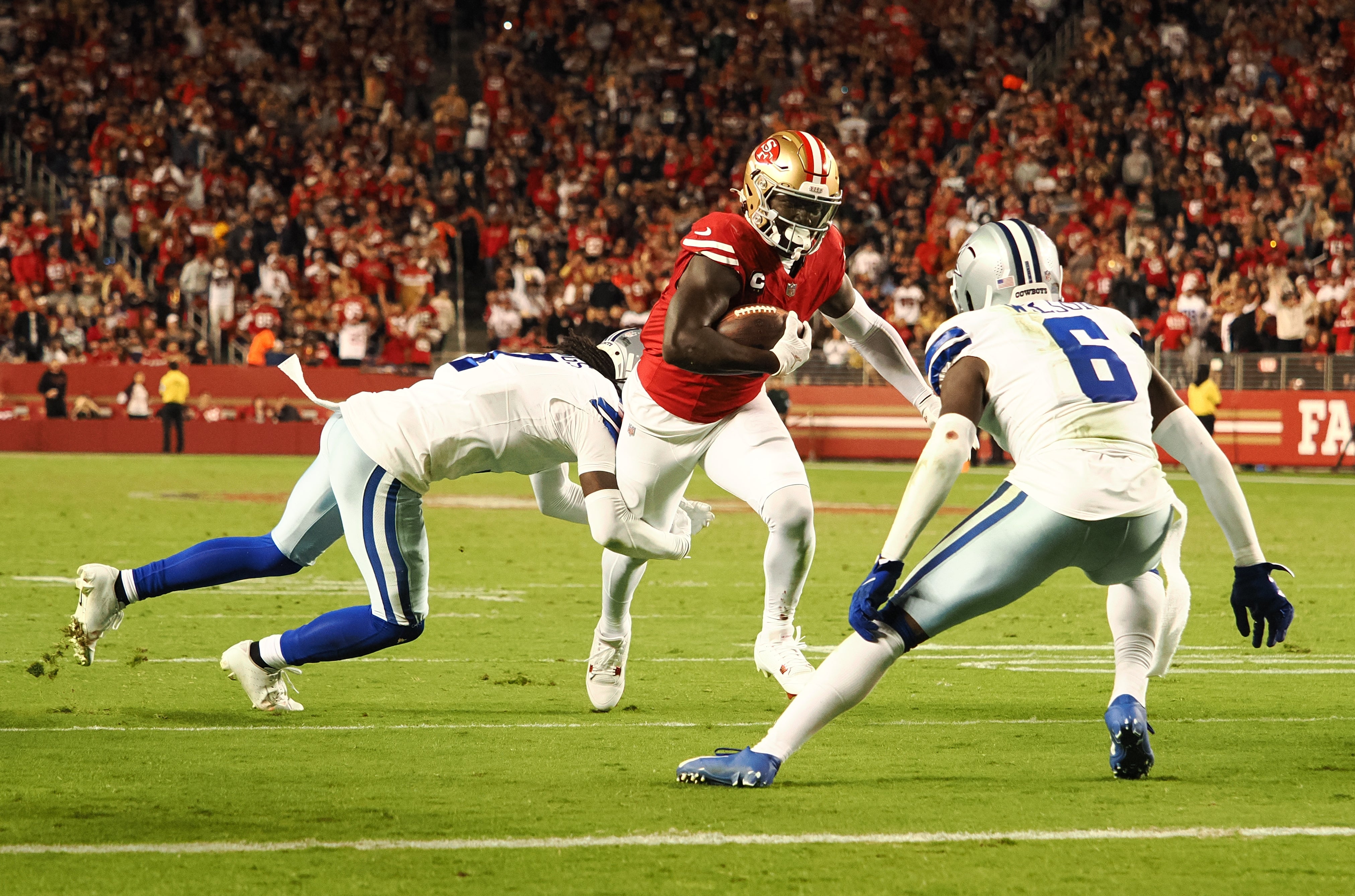 San Francisco 49ers wide receiver Deebo Samuel Sr (1) carries the ball against Dallas Cowboys cornerback Trevon Diggs (7) and safety Donovan Wilson (6) during the third quarter at Levi's Stadium.