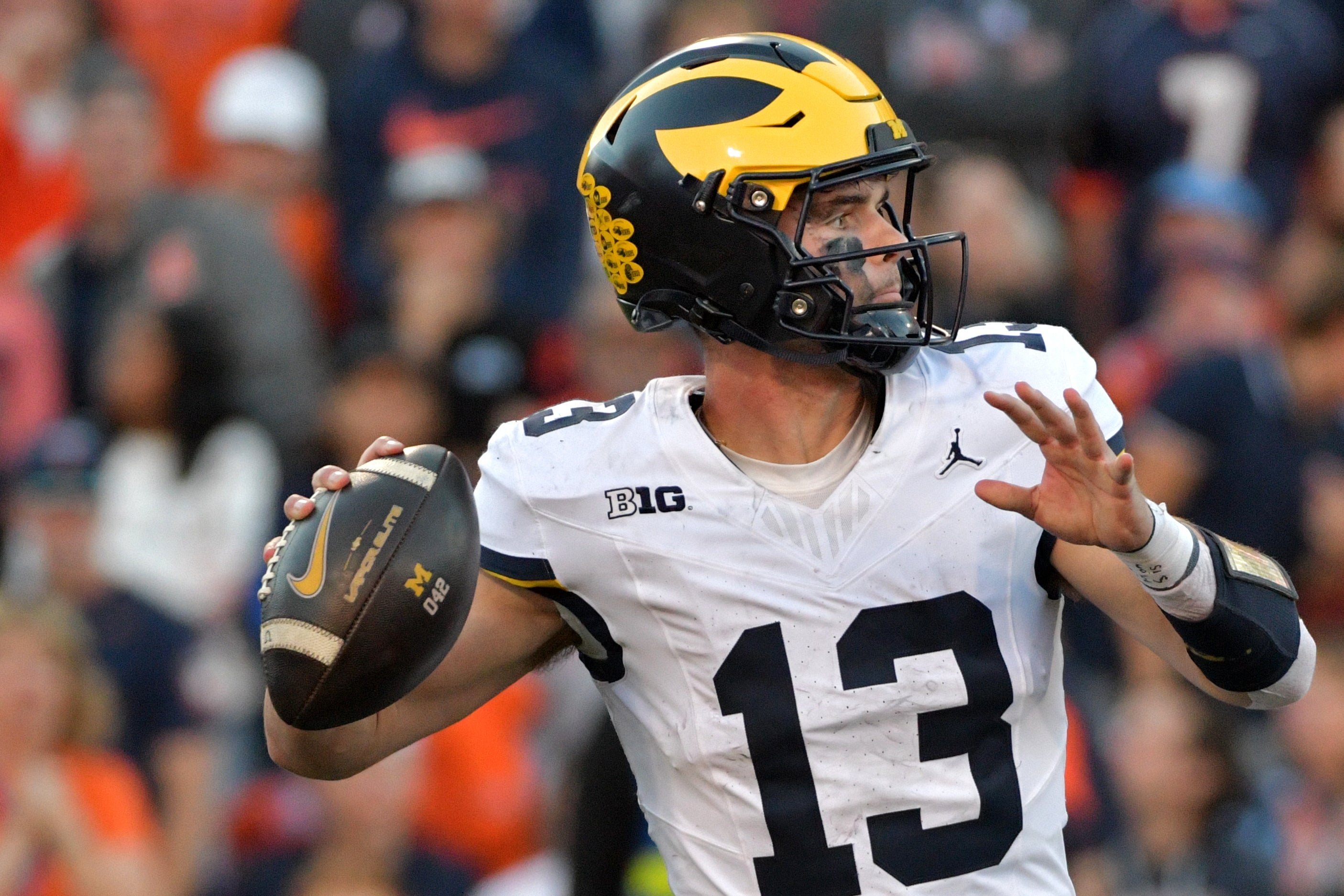 Caption: Oct 19, 2024; Champaign, Illinois, USA; Michigan Wolverines quarterback Jack Tuttle (13) throws against the Illinois Fighting Illini during the second half at Memorial Stadium.