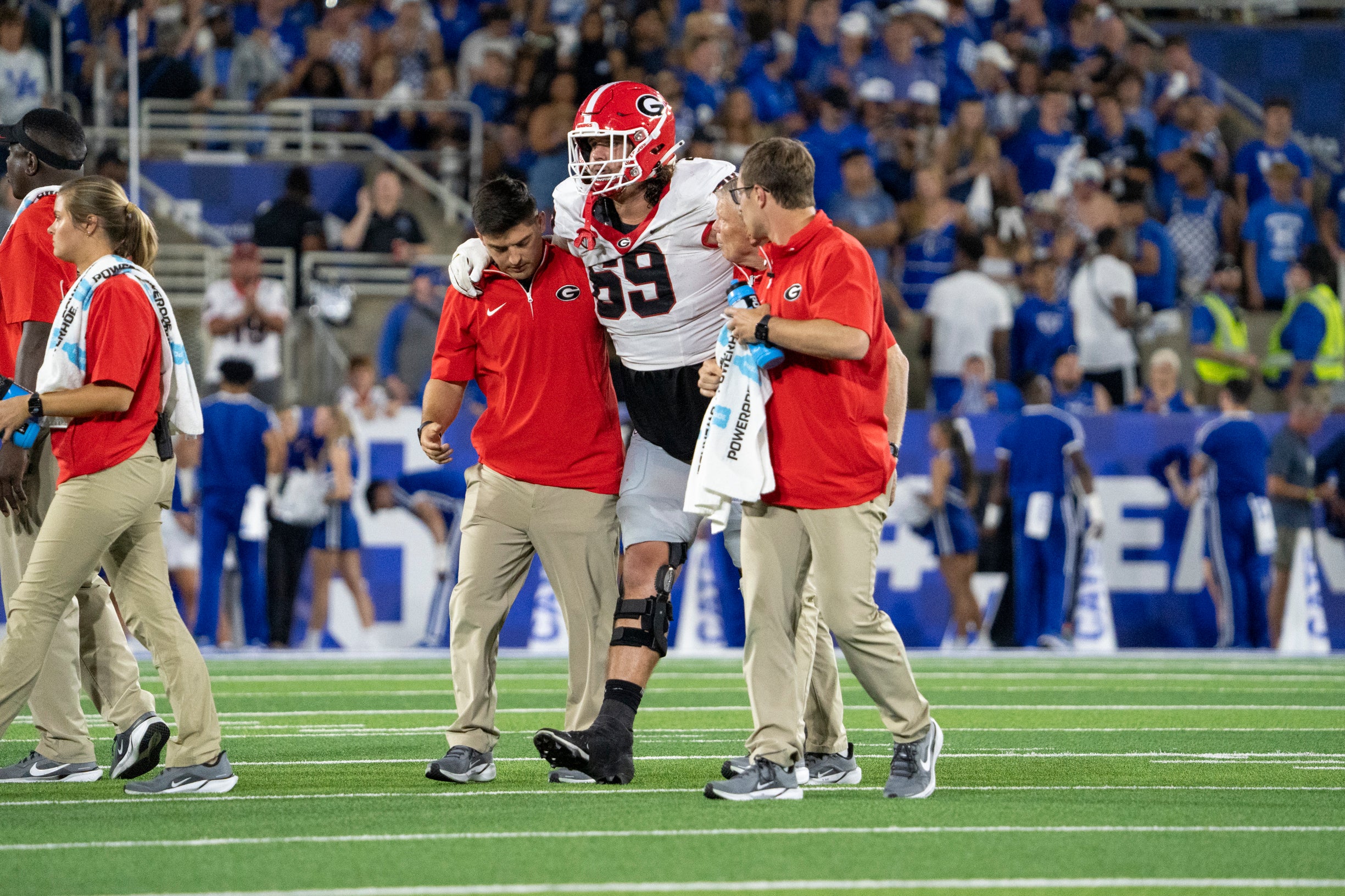 Georgia Bulldogs offensive lineman Tate Ratledge (69) is walked off the field after an injury during the second quarter against the Kentucky Wildcats at Kroger Field.