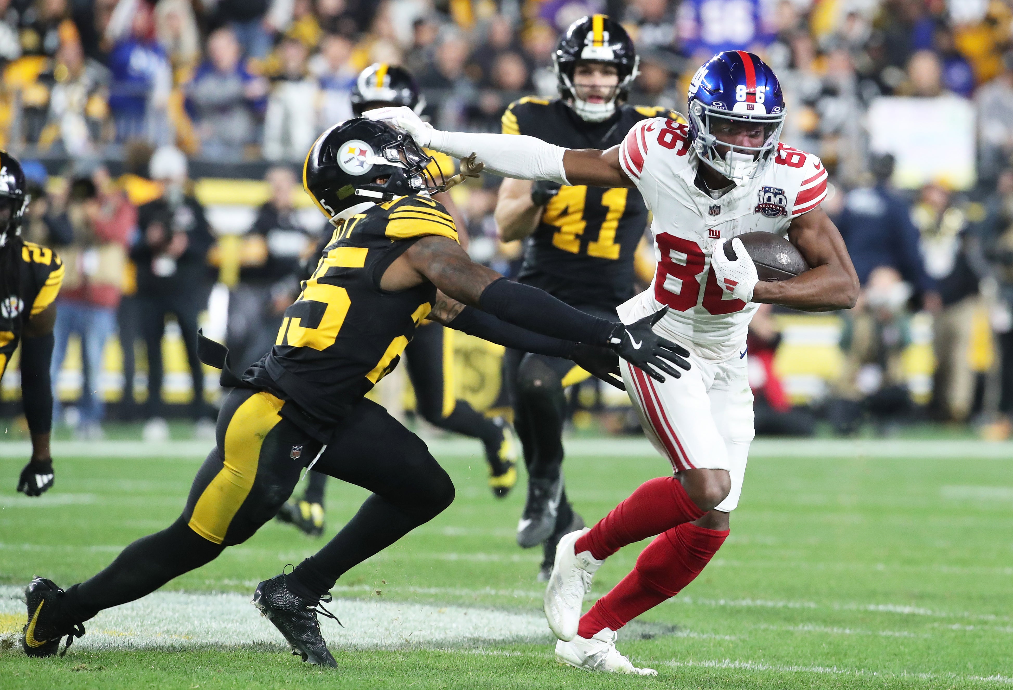 Oct 28, 2024; Pittsburgh, Pennsylvania, USA; New York Giants wide receiver Darius Slayton (86) runs after a catch as Pittsburgh Steelers safety DeShon Elliott (25) defends during the second quarter at Acrisure Stadium.