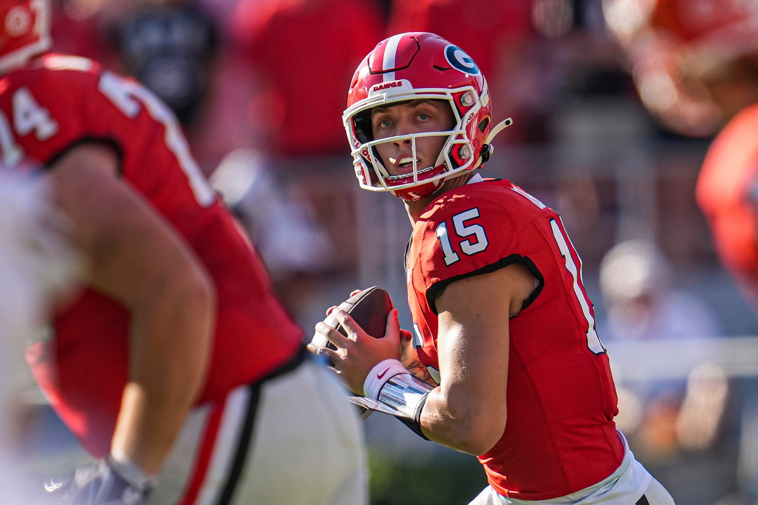 Georgia Bulldogs quarterback Carson Beck (15) rolls out against the Mississippi State Bulldogs during the first half at Sanford Stadium.