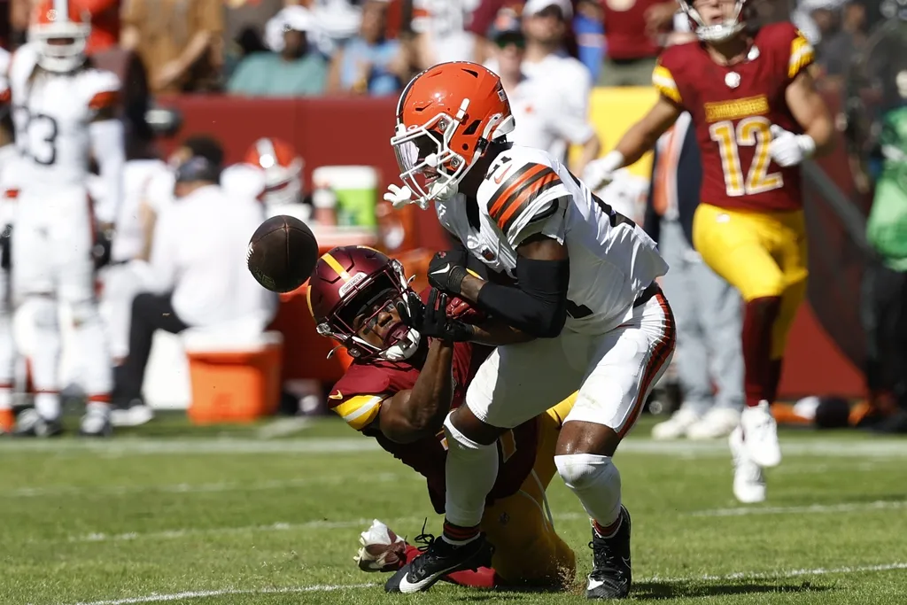 Cleveland Browns cornerback Denzel Ward (21) breaks up a pass intended for Washington Commanders wide receiver Terry McLaurin (17) during the second quarter at NorthWest Stadium.