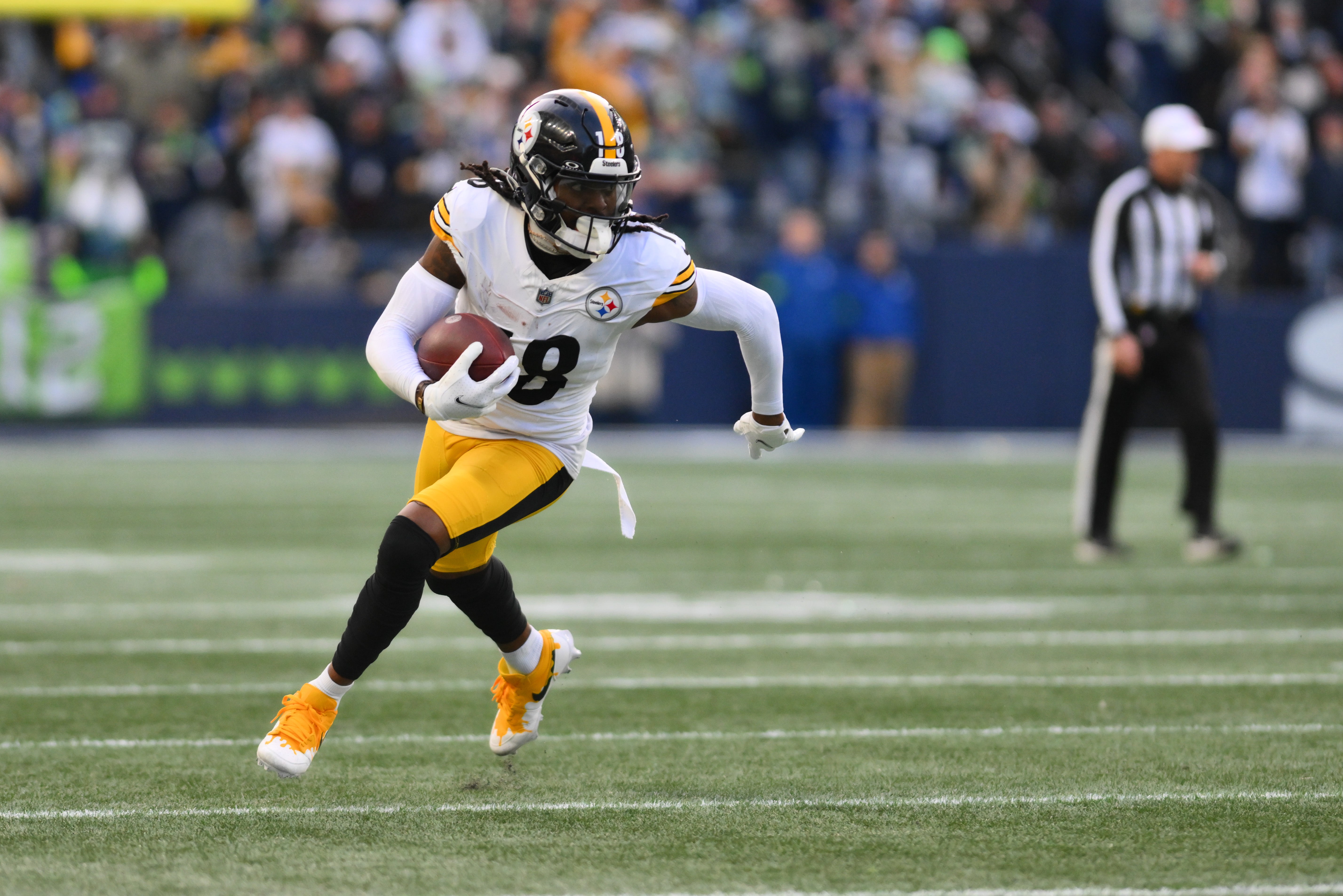 Dec 31, 2023; Seattle, Washington, USA; Pittsburgh Steelers wide receiver Diontae Johnson (18) carries the ball against the Seattle Seahawks during the second half at Lumen Field.