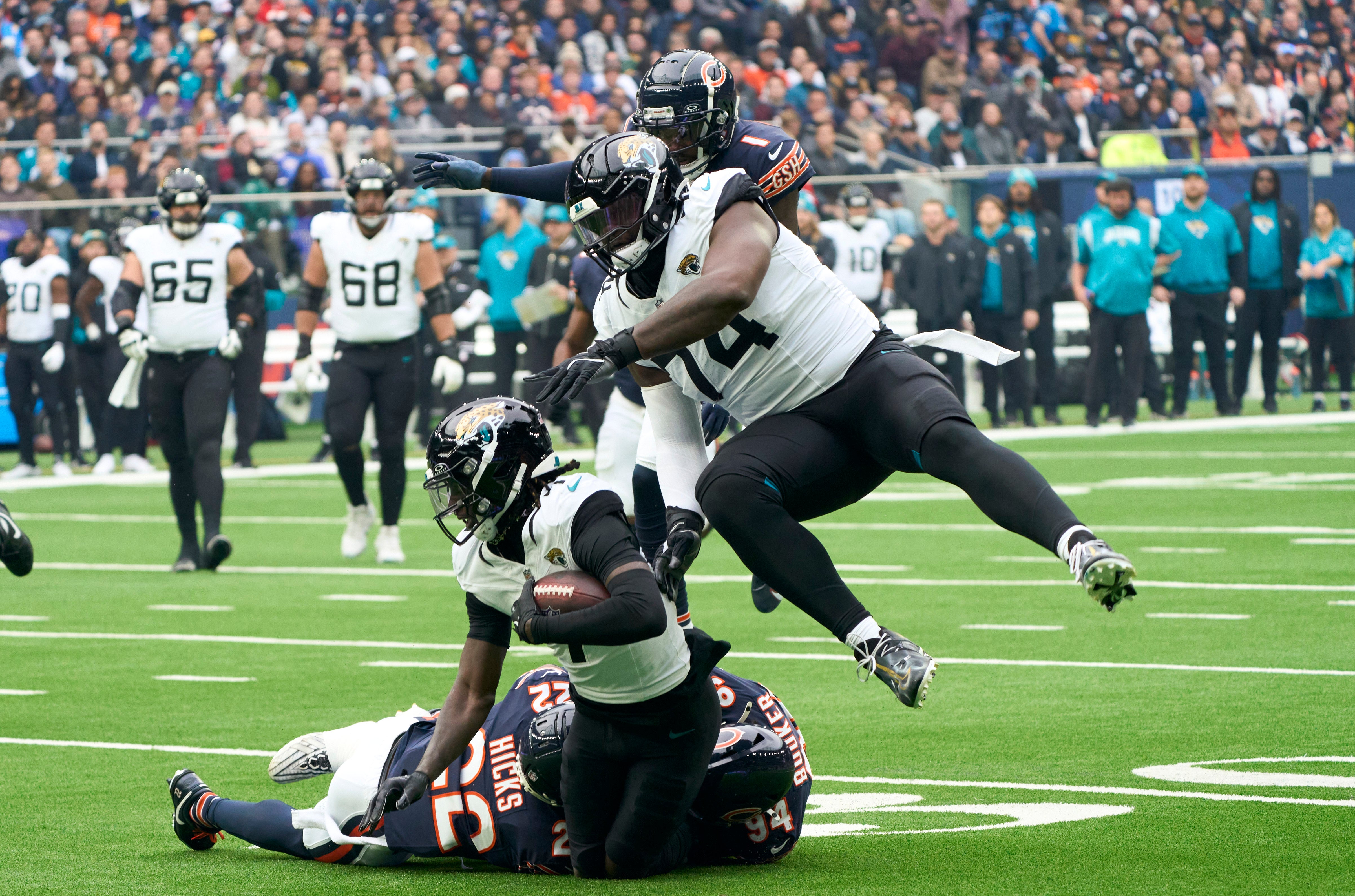 Oct 13, 2024; London, United Kingdom; Jacksonville Jaguars wide receiver Brian Thomas Jr. (7) carries the ball protected by offensive tackle Cam Robinson (74) during the first half of an NFL International Series game against the Chicago Bears at Tottenham Hotspur Stadium.