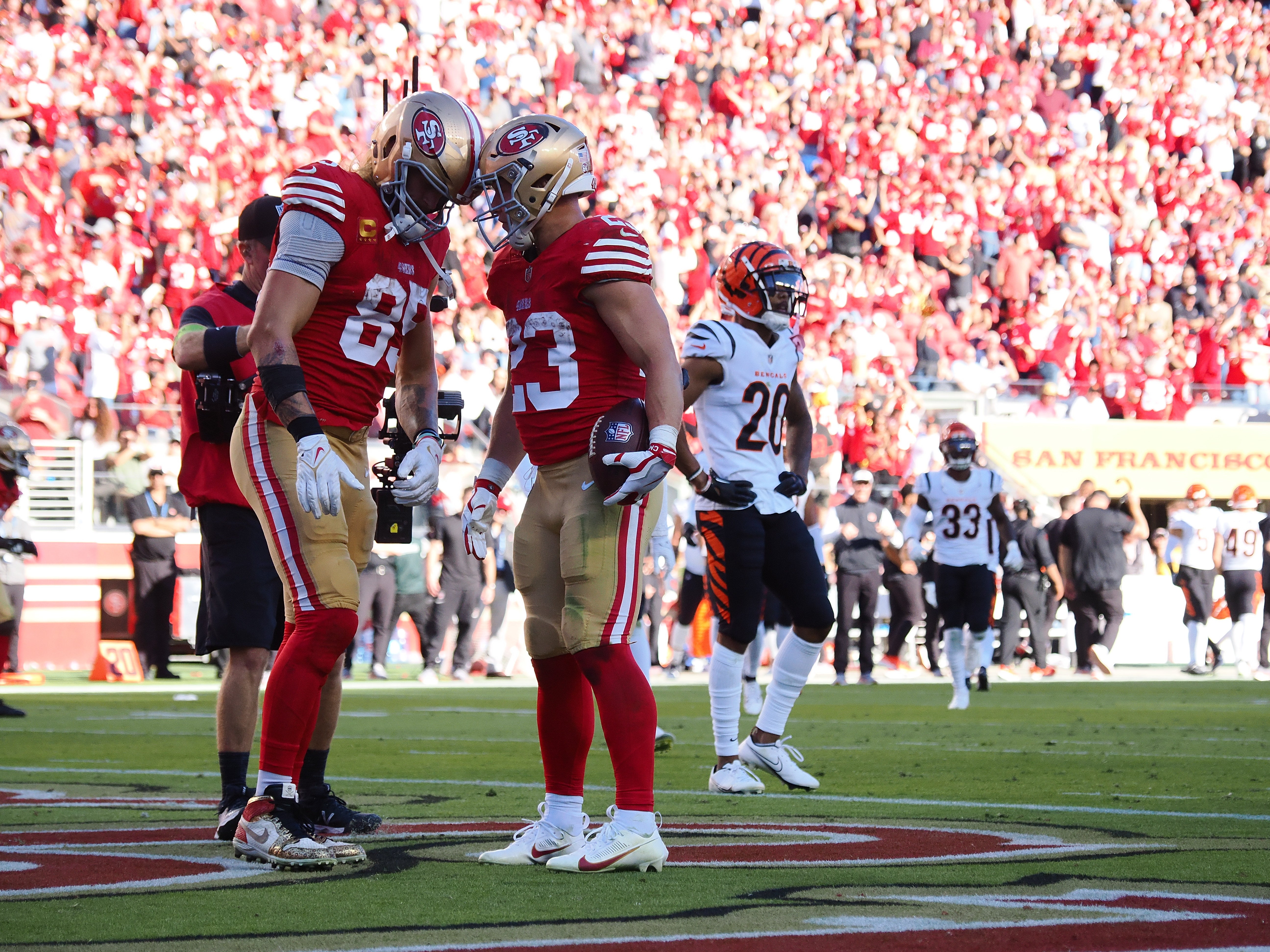 San Francisco 49ers tight end George Kittle (85) and running back Christian McCaffrey (23) put their helmets together after McCaffrey scored a touchdown against the Cincinnati Bengals during the fourth quarter at Levi's Stadium.