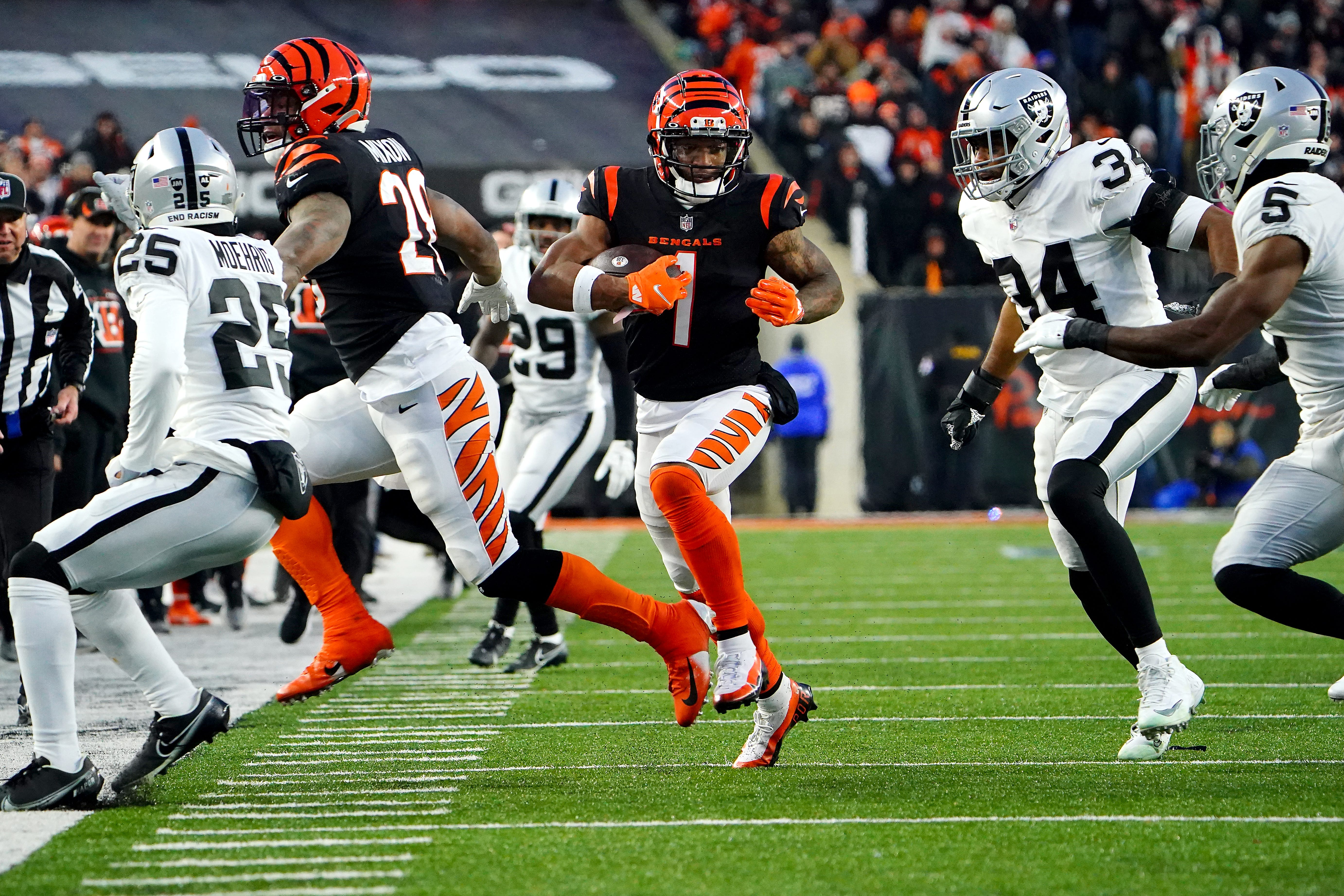 Cincinnati Bengals wide receiver Ja'Marr Chase (1) carries the ball for a first down in the second quarter during an NFL AFC wild-card playoff game against the Las Vegas Raiders, Saturday, Jan. 15, 2022, at Paul Brown Stadium in Cincinnati. Las Vegas Raiders At Cincinnati Bengals Jan 15 Afc Wild Card Game
