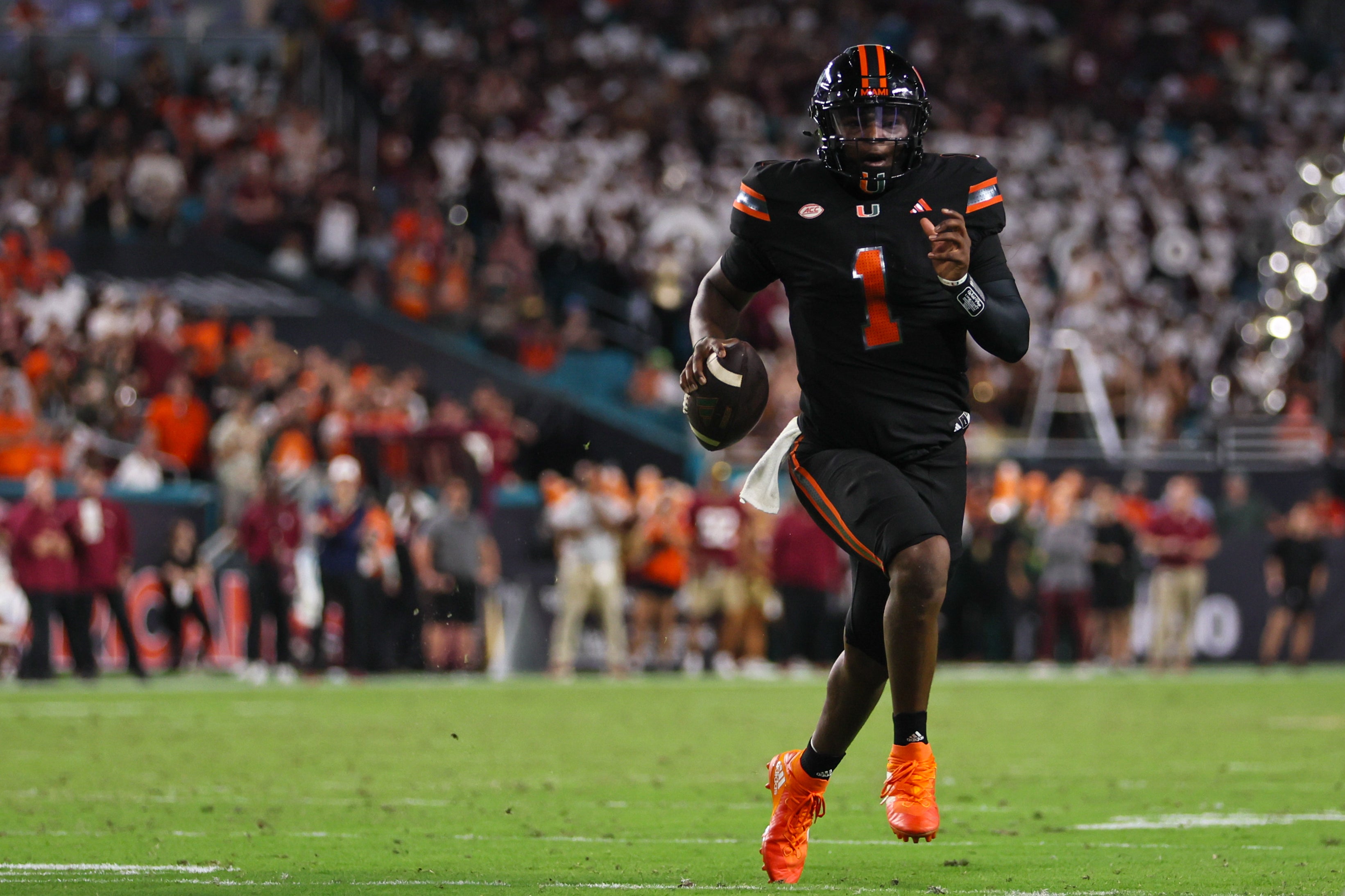 Miami Hurricanes quarterback Cam Ward (1) runs with the football against the Florida State Seminoles during the second quarter at Hard Rock Stadium.