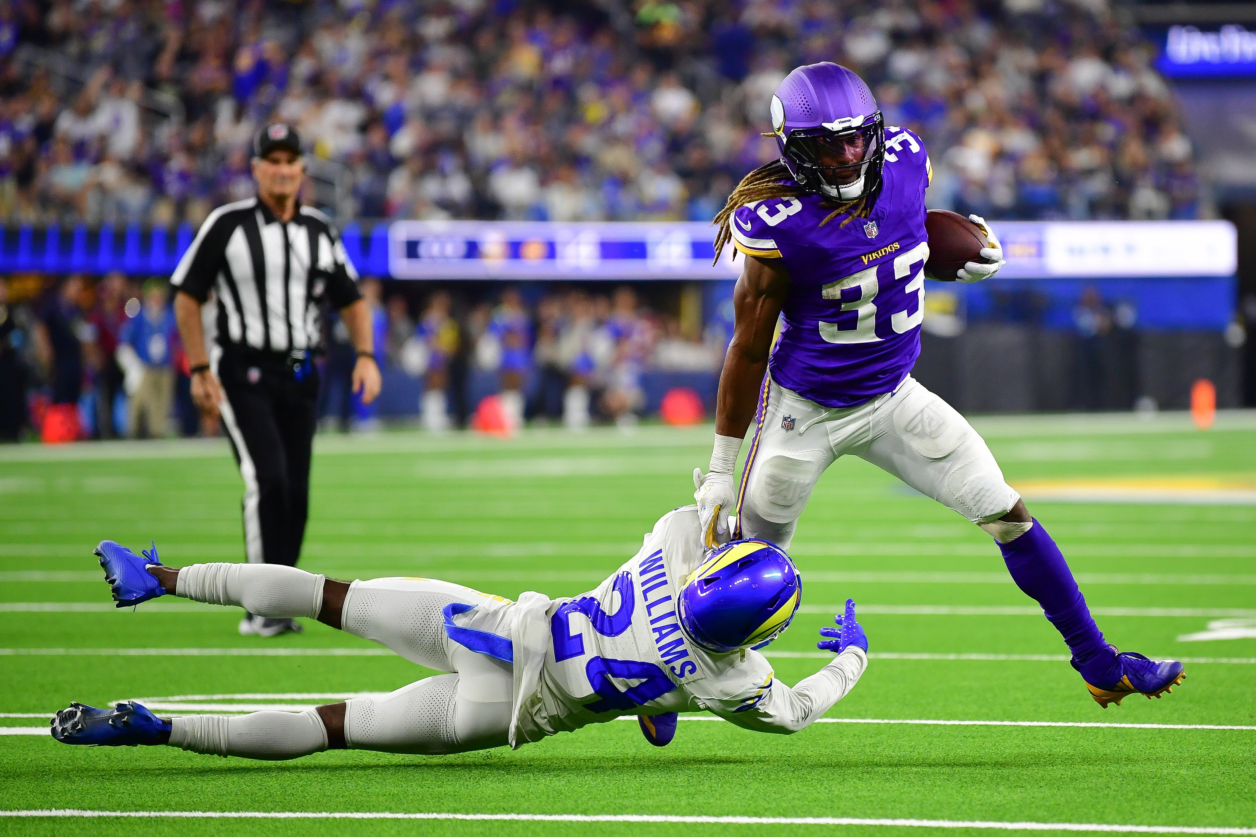Oct 24, 2024; Inglewood, California, USA; Minnesota Vikings running back Aaron Jones (33) runs the ball against Los Angeles Rams cornerback Darious Williams (24) during the second half at SoFi Stadium.