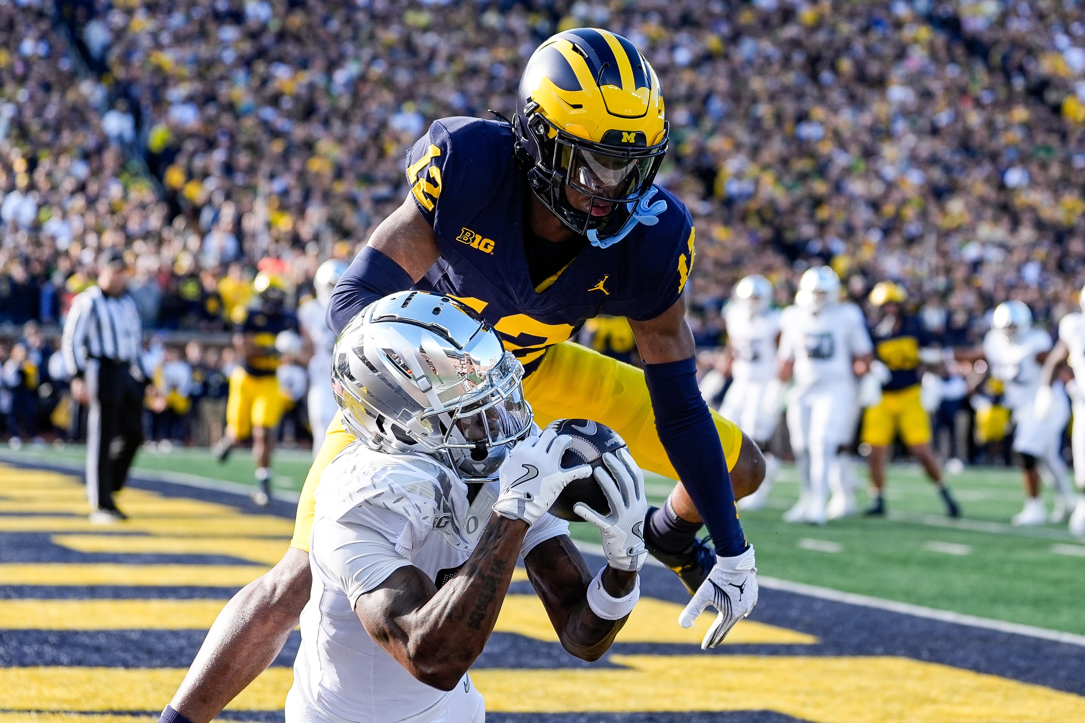 Oregon wide receiver Evan Stewart (7) makes a catch for a touchdown against Michigan defensive back Aamir Hall (12) during the first half at Michigan Stadium in Ann Arbor on Saturday, Nov. 2, 2024.