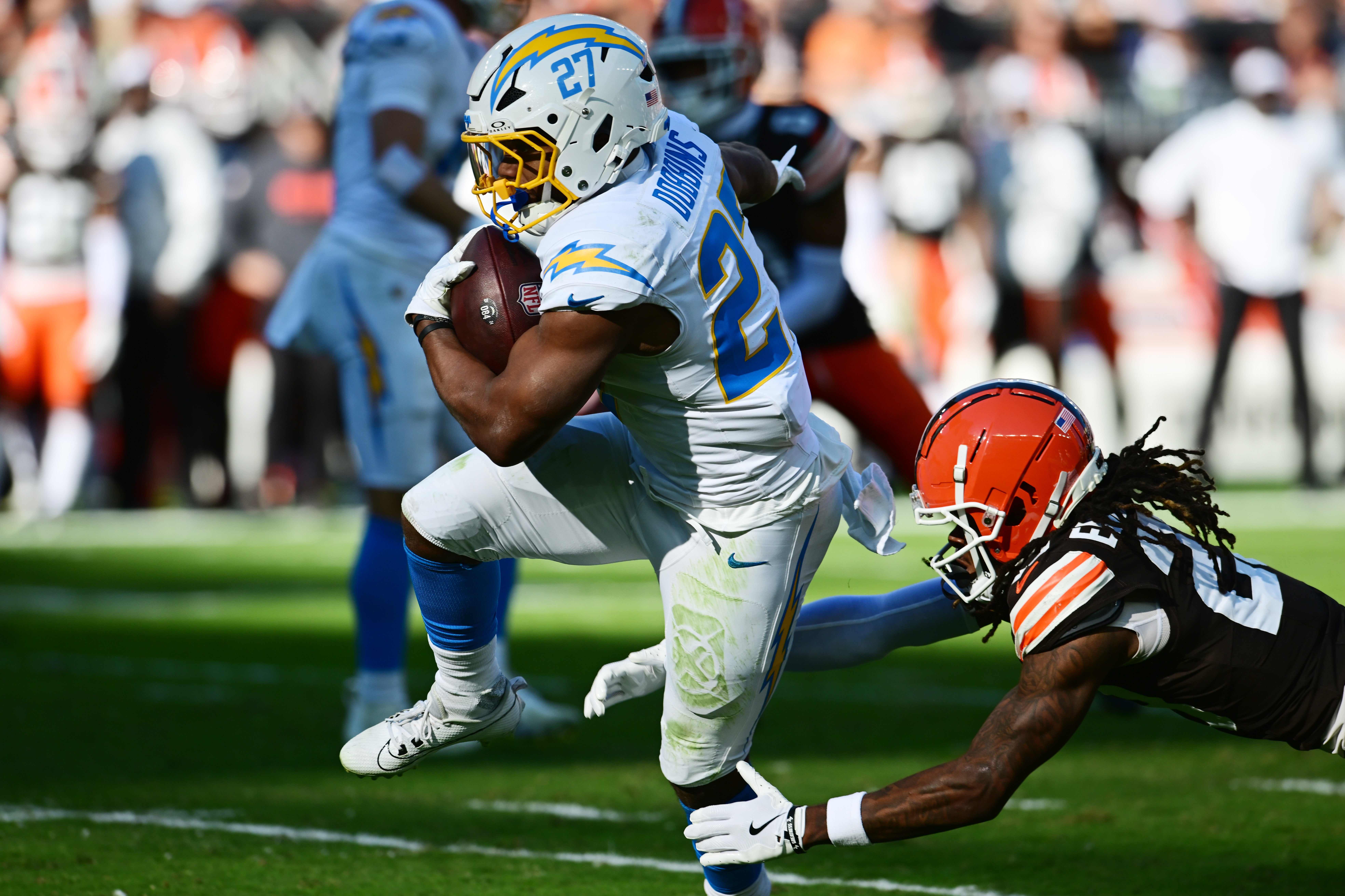 Los Angeles Chargers running back J.K. Dobbins (27) scores a touchdown as Cleveland Browns cornerback Martin Emerson Jr. (23) defends during the first quarter at Huntington Bank Field.