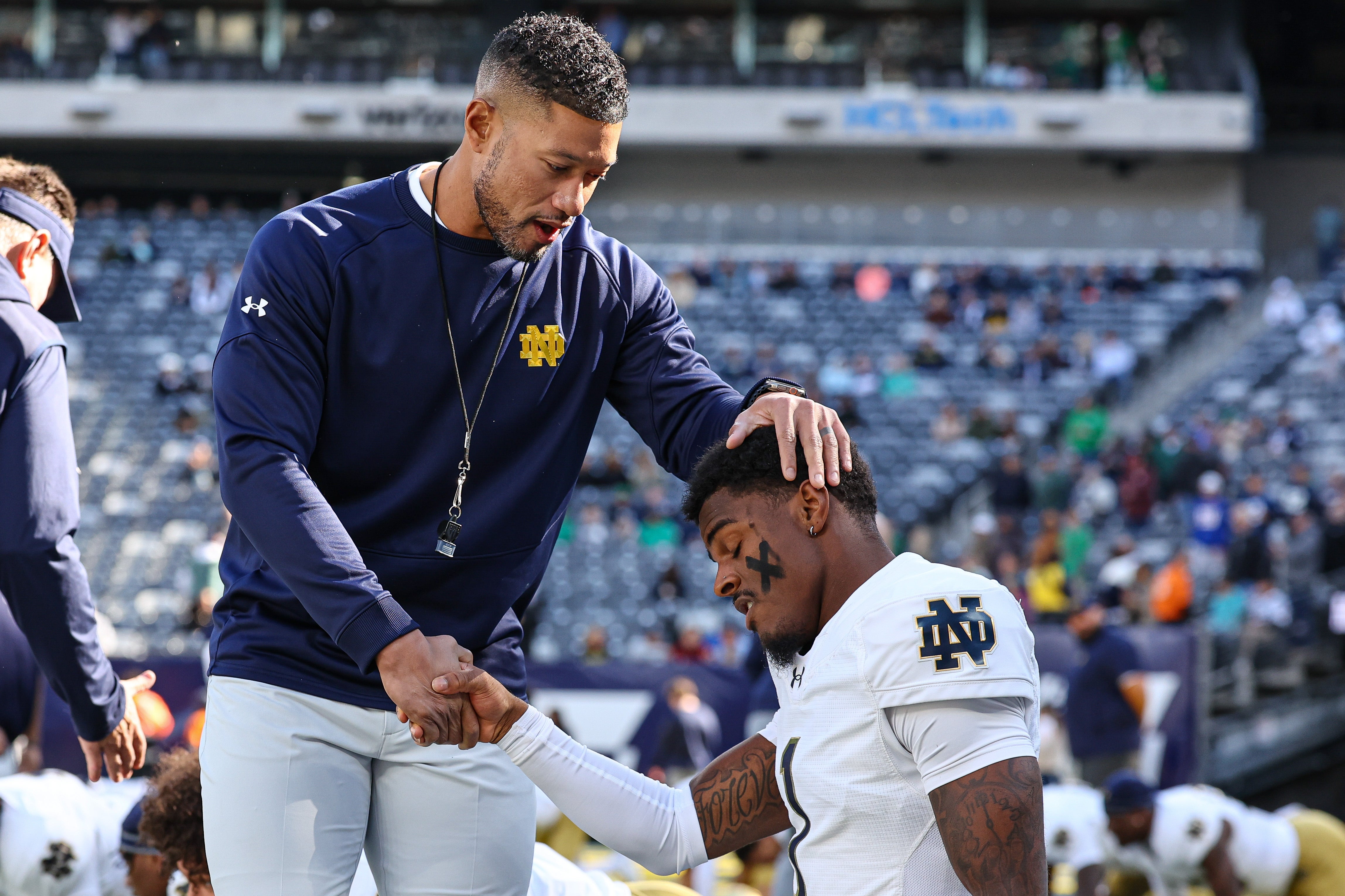 Notre Dame Fighting Irish head coach Marcus Freeman greets players before the game against the Navy Midshipmen at MetLife Stadium.