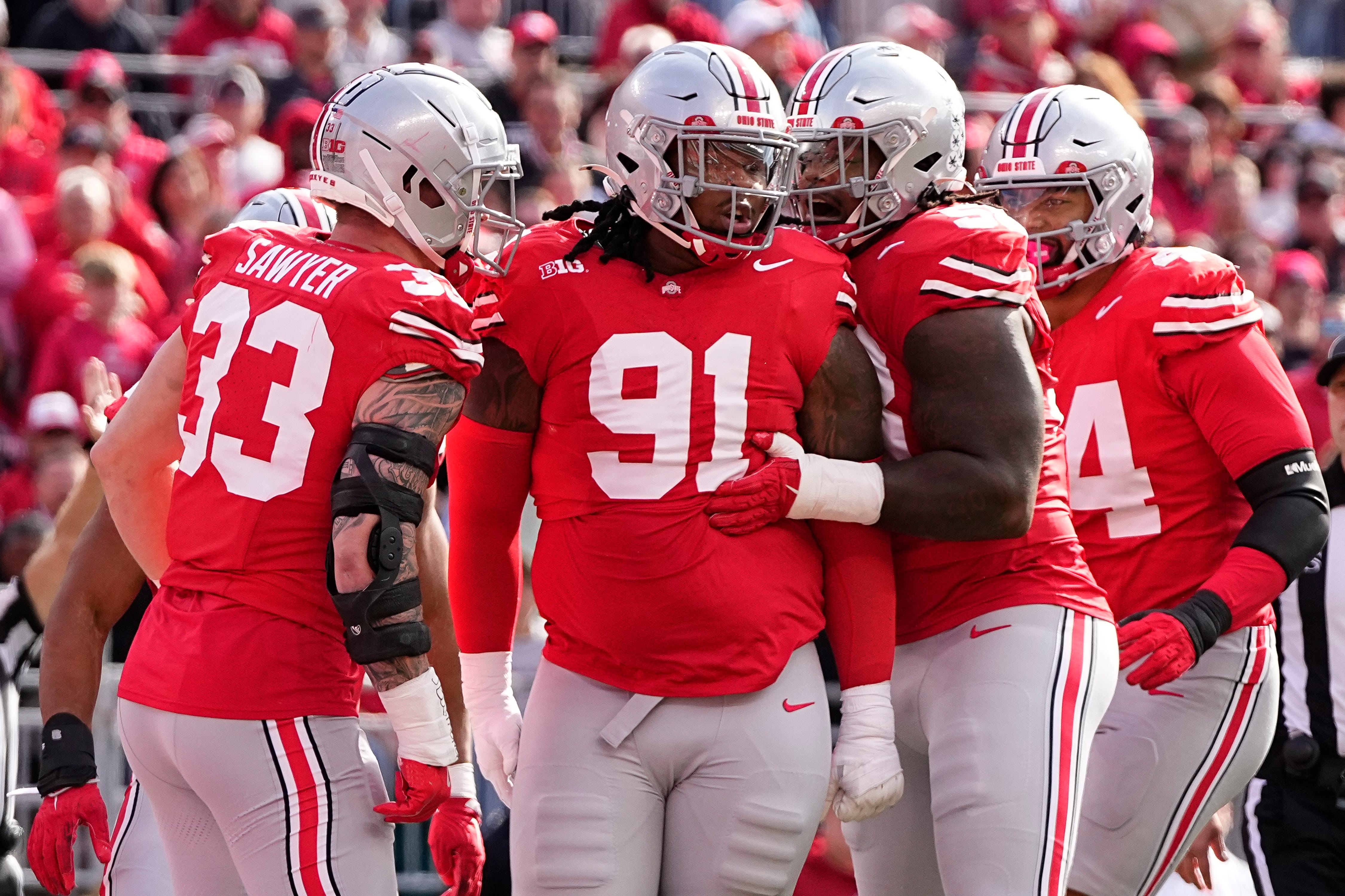 Ohio State Buckeyes defensive end Jack Sawyer (33) and defensive tackle Ty Hamilton (58) celebrate a tackle by defensive tackle Tyleik Williams (91) during the first half of the NCAA football game against the Nebraska Cornhuskers at Ohio Stadium in Columbus on Saturday, Oct. 26, 2024.