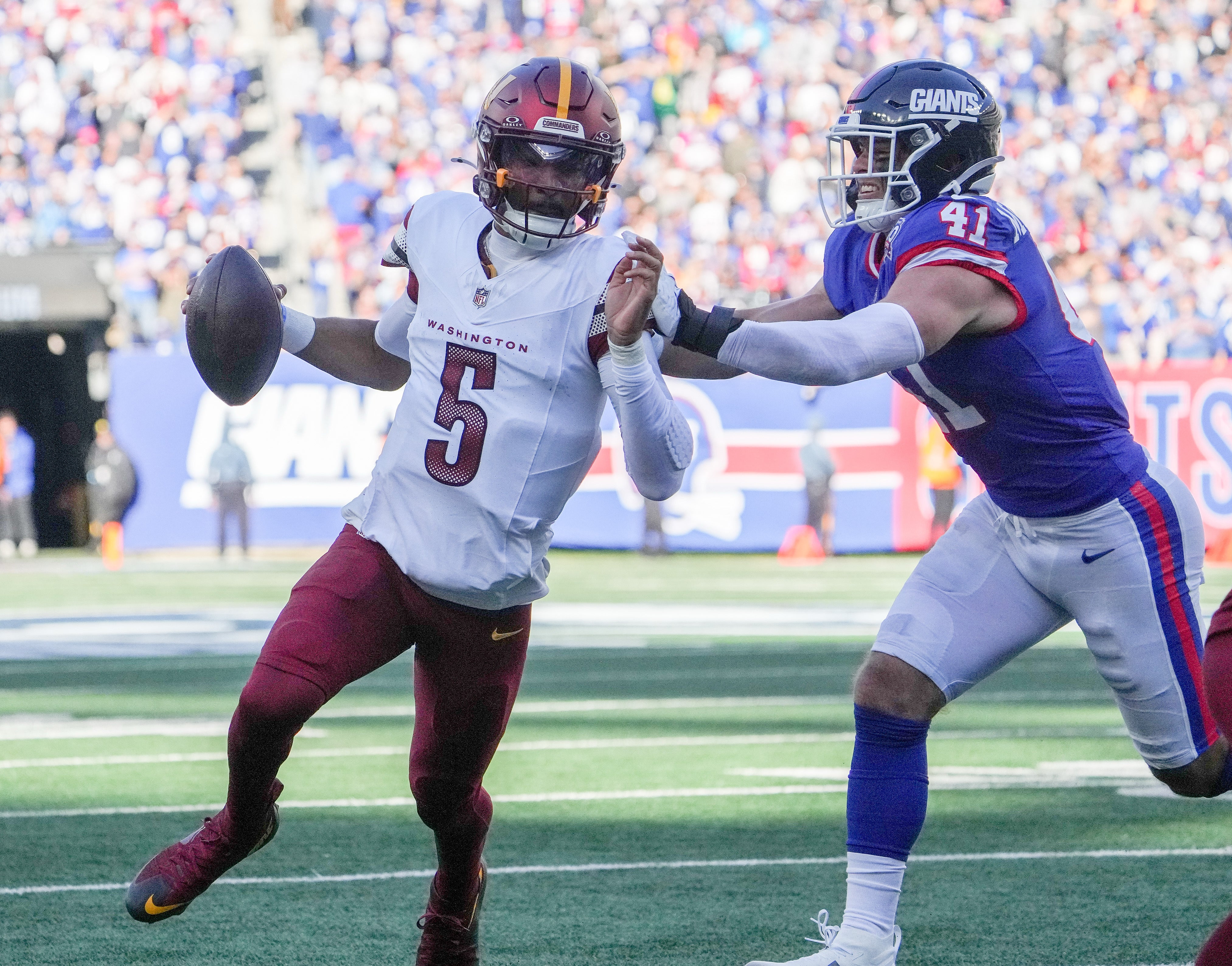 Nov 3, 2024; East Rutherford, New Jersey, USA; Washington Commanders quarterback Jayden Daniels (5) scrambles for a few yards against the New York Giants during the first half at MetLife Stadium.