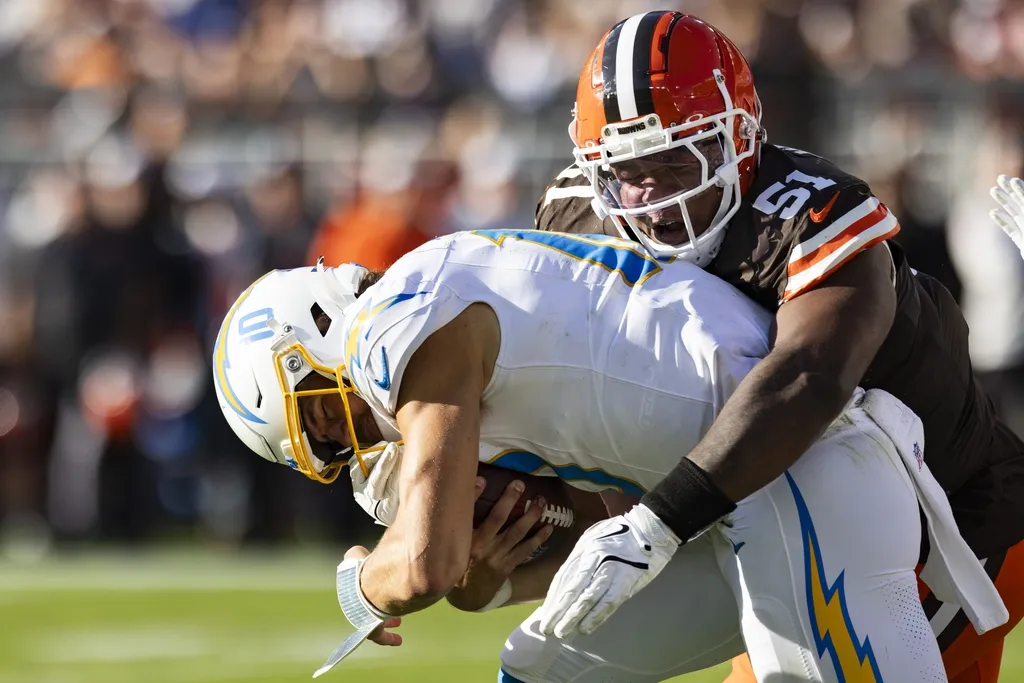Cleveland Browns defensive tackle Mike Hall Jr. (51) tackles Los Angeles Chargers quarterback Justin Herbert (10) during the third quarter at Huntington Bank Field.