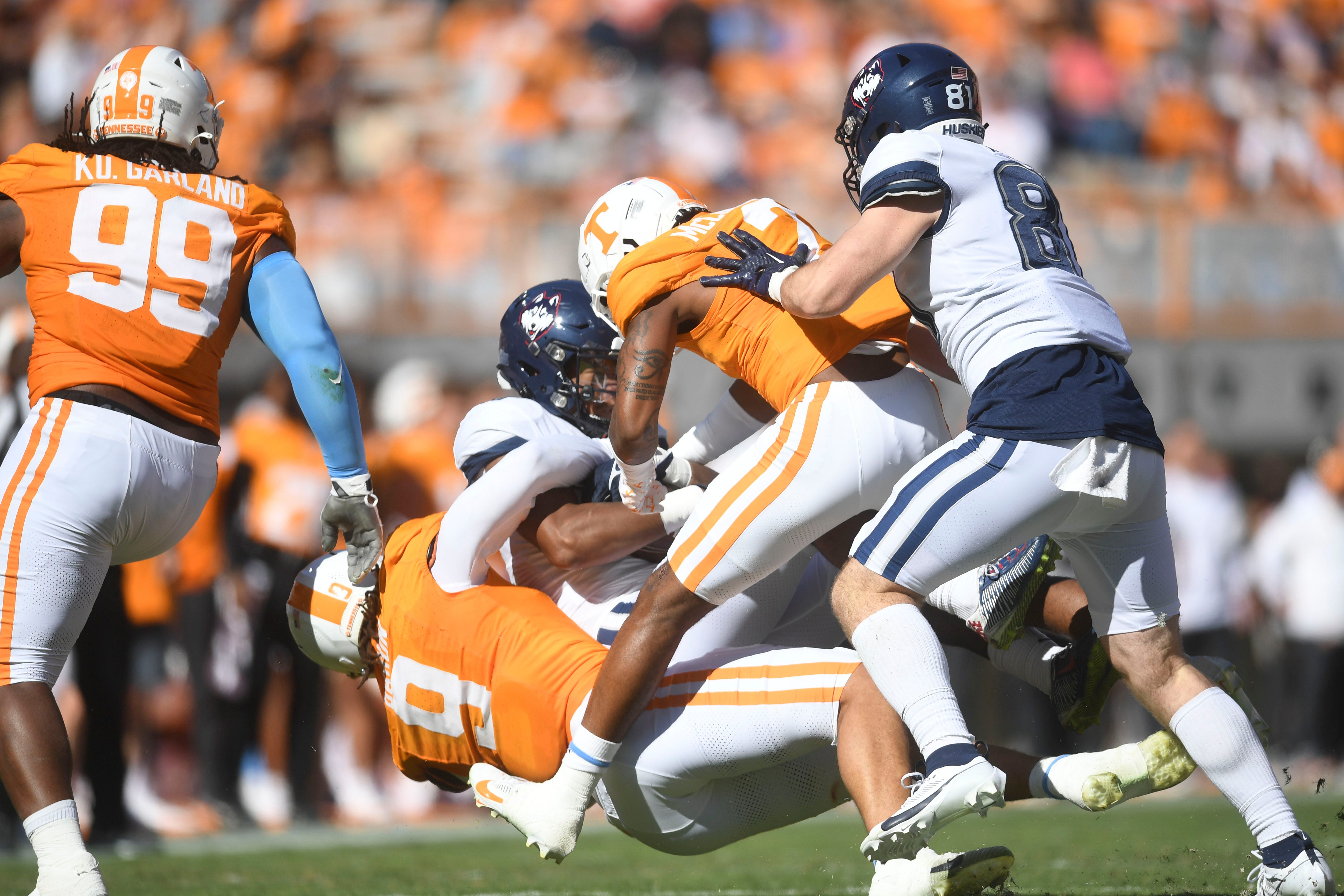 UConn tight end Justin Joly (17) is stopped by Tennessee defensive lineman Tyler Baron (9) and defensive back Jaylen McCollough (2) during an NCAA college football game on Saturday, November 4, 2023 in Knoxville, Tenn.