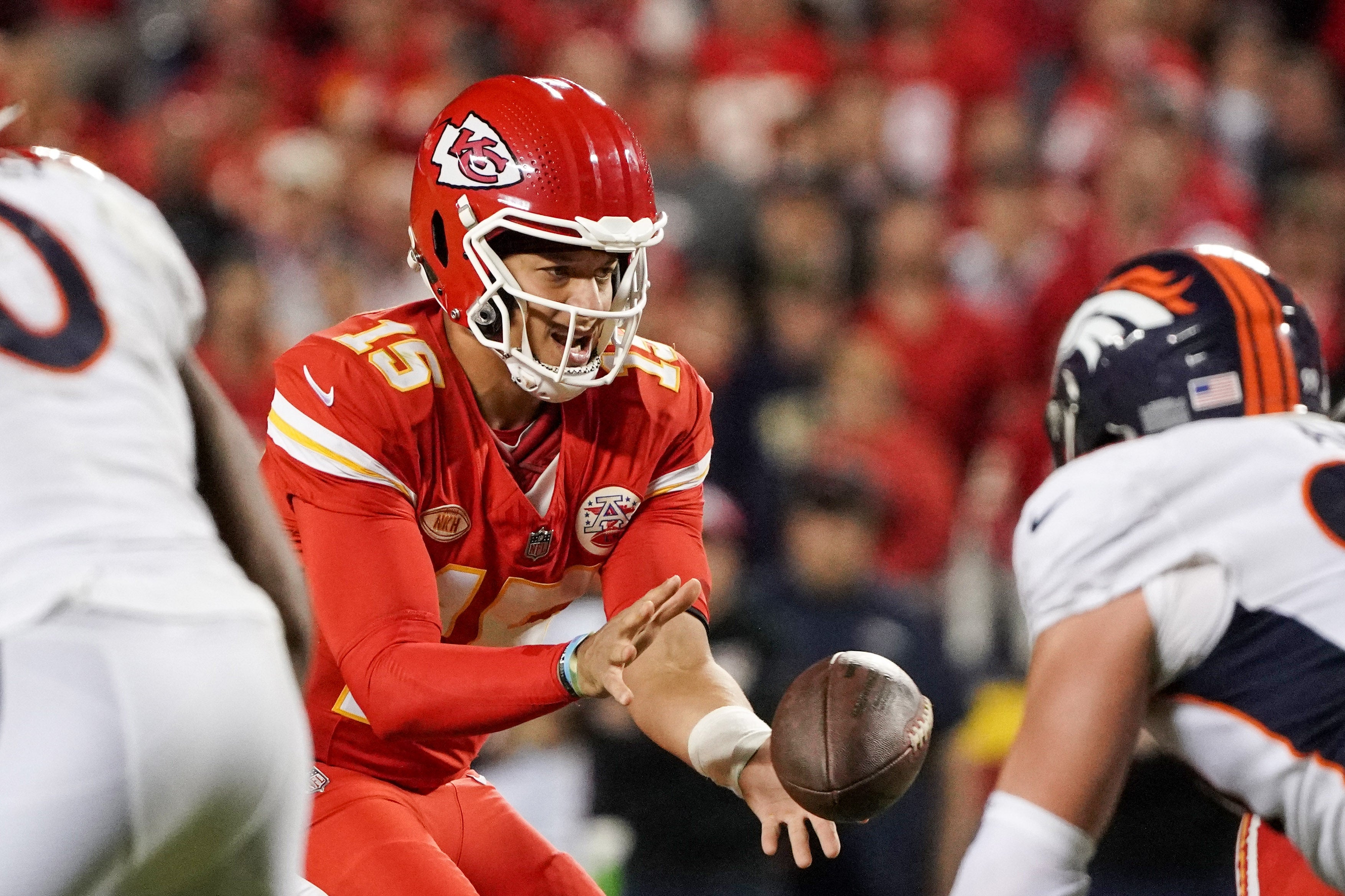 Oct 12, 2023; Kansas City, Missouri, USA; Kansas City Chiefs quarterback Patrick Mahomes (15) receives the snap against the Denver Broncos during the game at GEHA Field at Arrowhead Stadium.