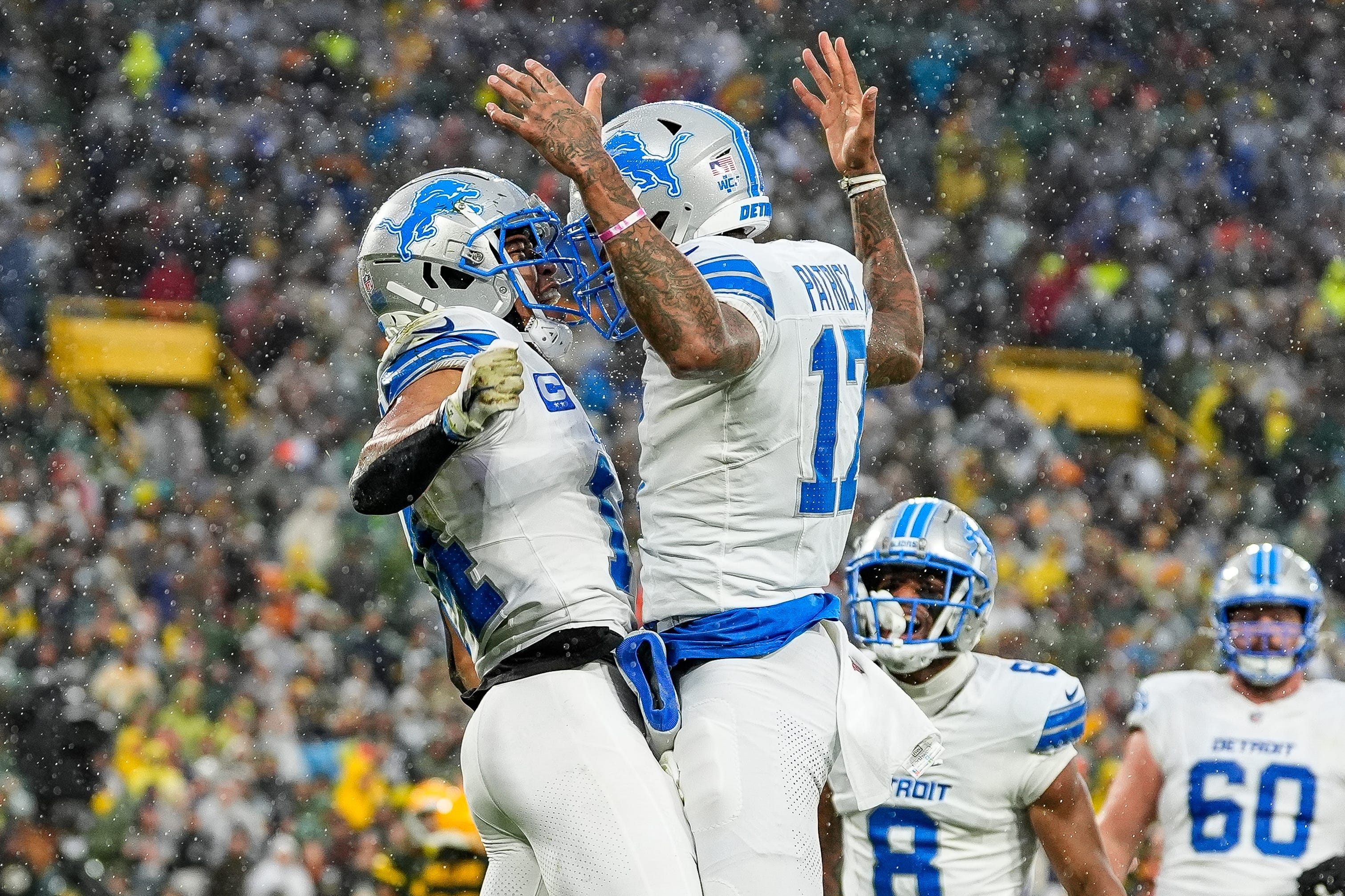 Lions wide receiver Amon-Ra St. Brown celebrates his touchdown catch against the Packers with receiver Tim Patrick.
