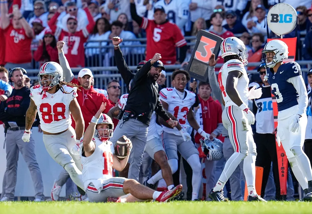 Ohio State Buckeyes quarterback Will Howard (18) and head coach Ryan Day react as Howard slides for a first down late in the second half of the NCAA football game at Beaver Stadium in University Park