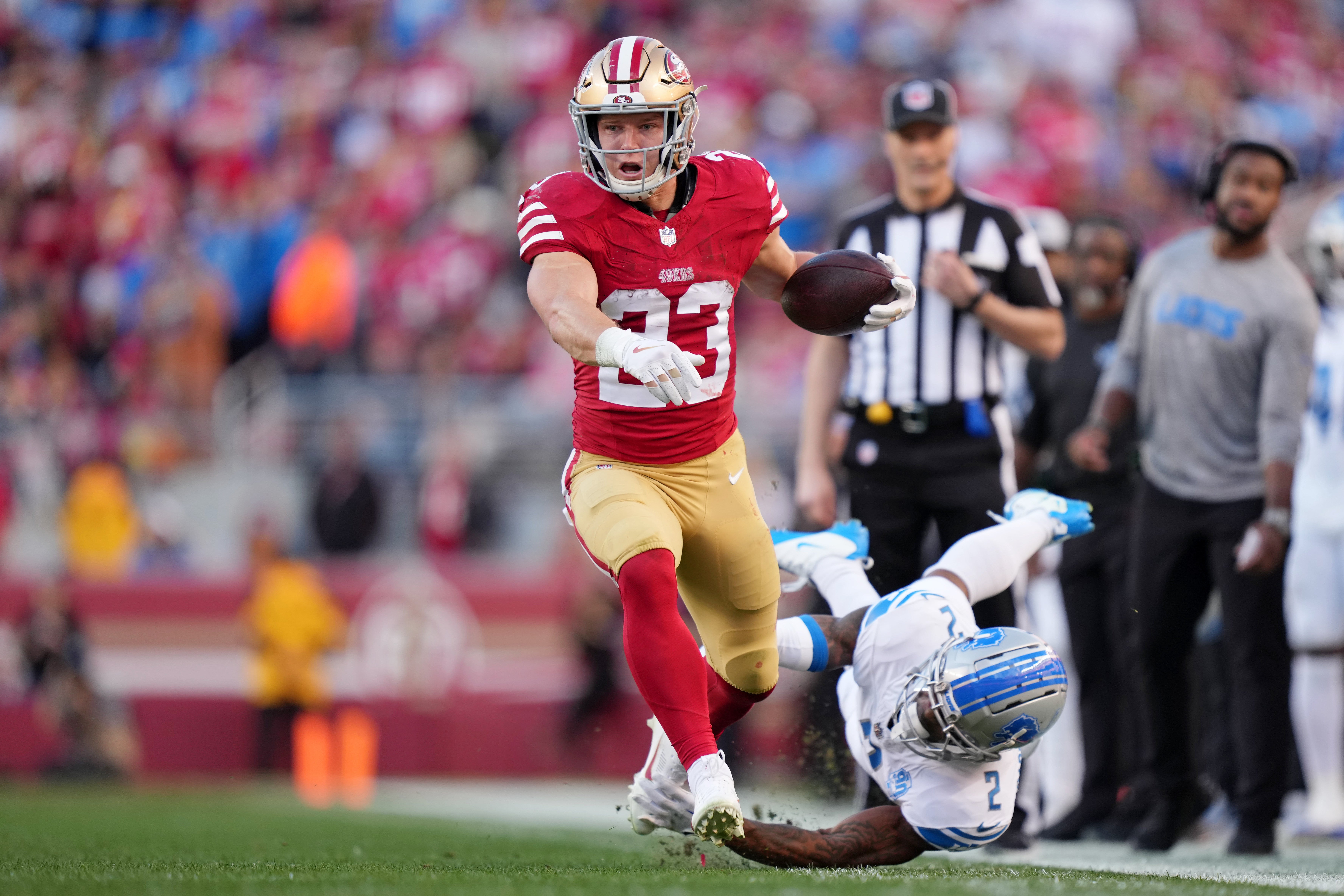 San Francisco 49ers running back Christian McCaffrey (23) runs with the ball against Detroit Lions safety C.J. Gardner-Johnson (2) during the first half of the NFC Championship football game at Levi's Stadium.