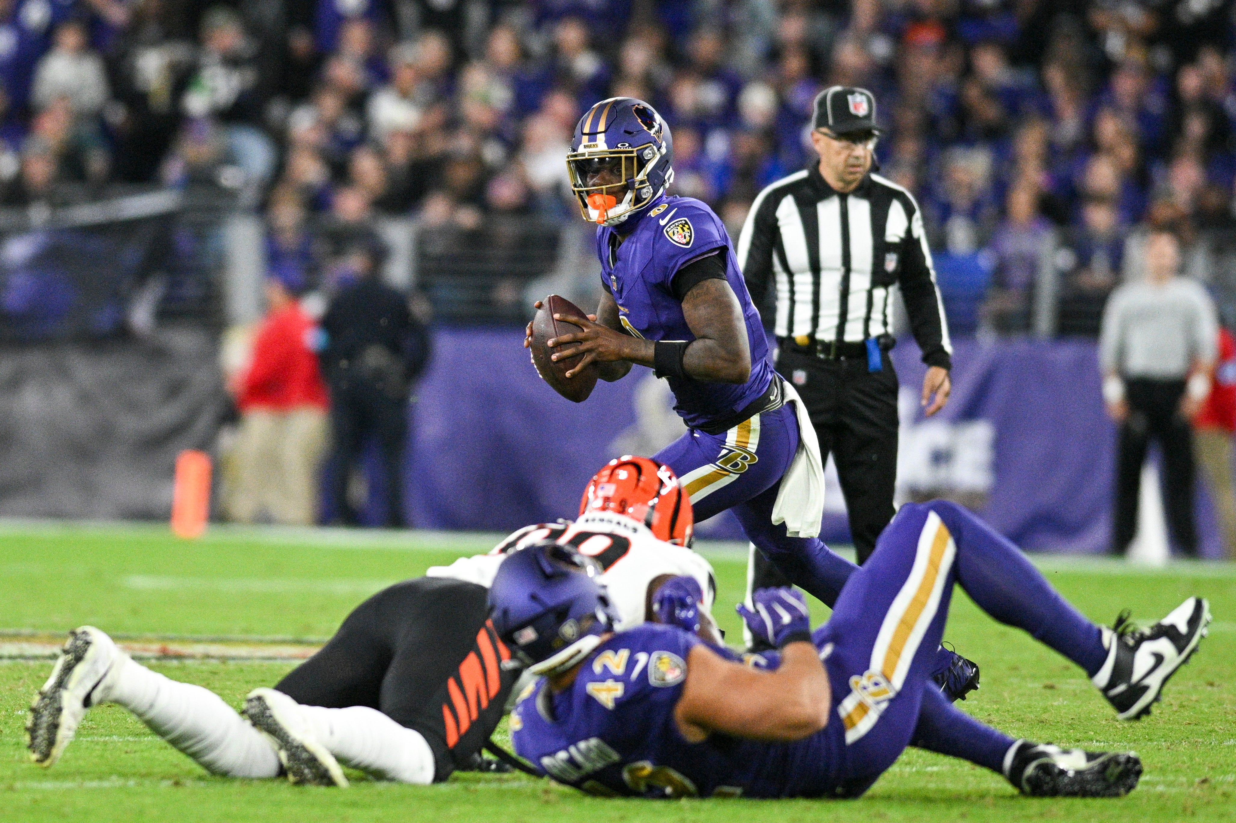 Nov 7, 2024; Baltimore, Maryland, USA; Baltimore Ravens quarterback Lamar Jackson (8) rolls out to pass during the first half against the Cincinnati Bengals at M&T Bank Stadium.