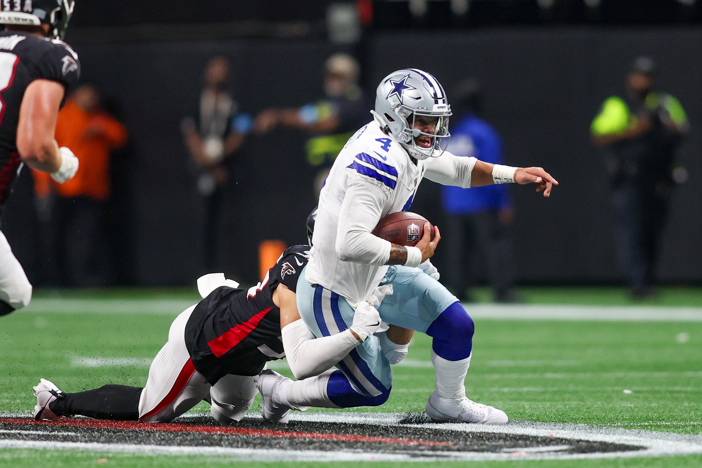 Dallas Cowboys quarterback Dak Prescott (4) scrambles against the Atlanta Falcons in the third quarter at Mercedes-Benz Stadium.