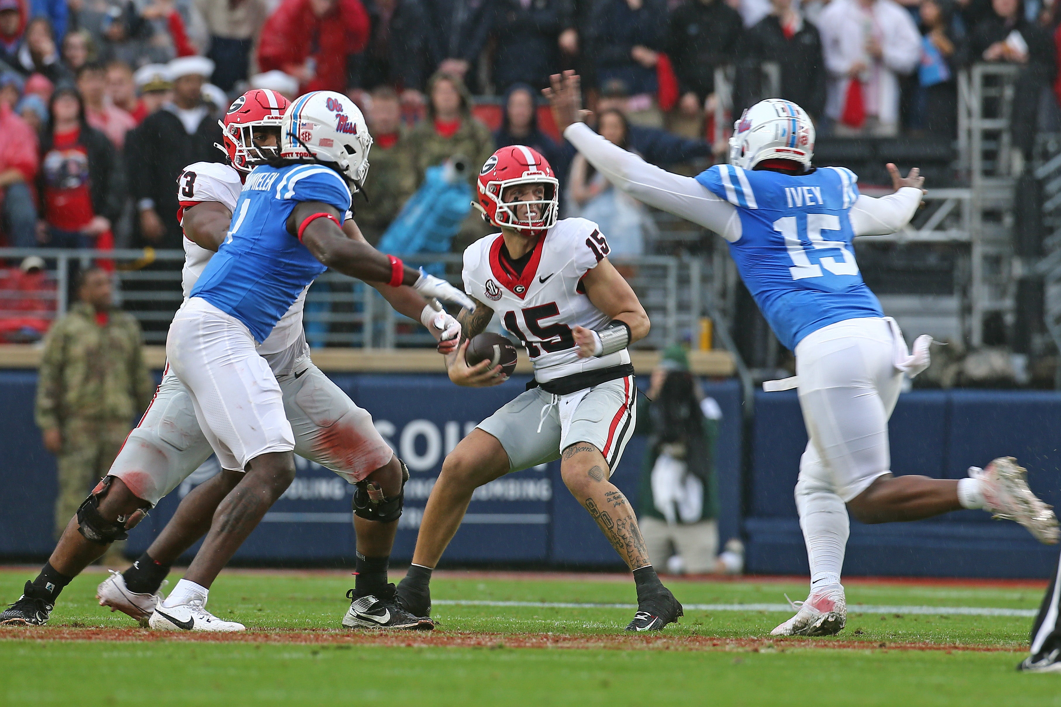 Nov 9, 2024; Oxford, Mississippi, USA; Georgia Bulldogs quarterback Carson Beck (15) drops back to pass as Mississippi Rebels defensive Jared Ivey (15) rushes during the first half at Vaught-Hemingway Stadium.