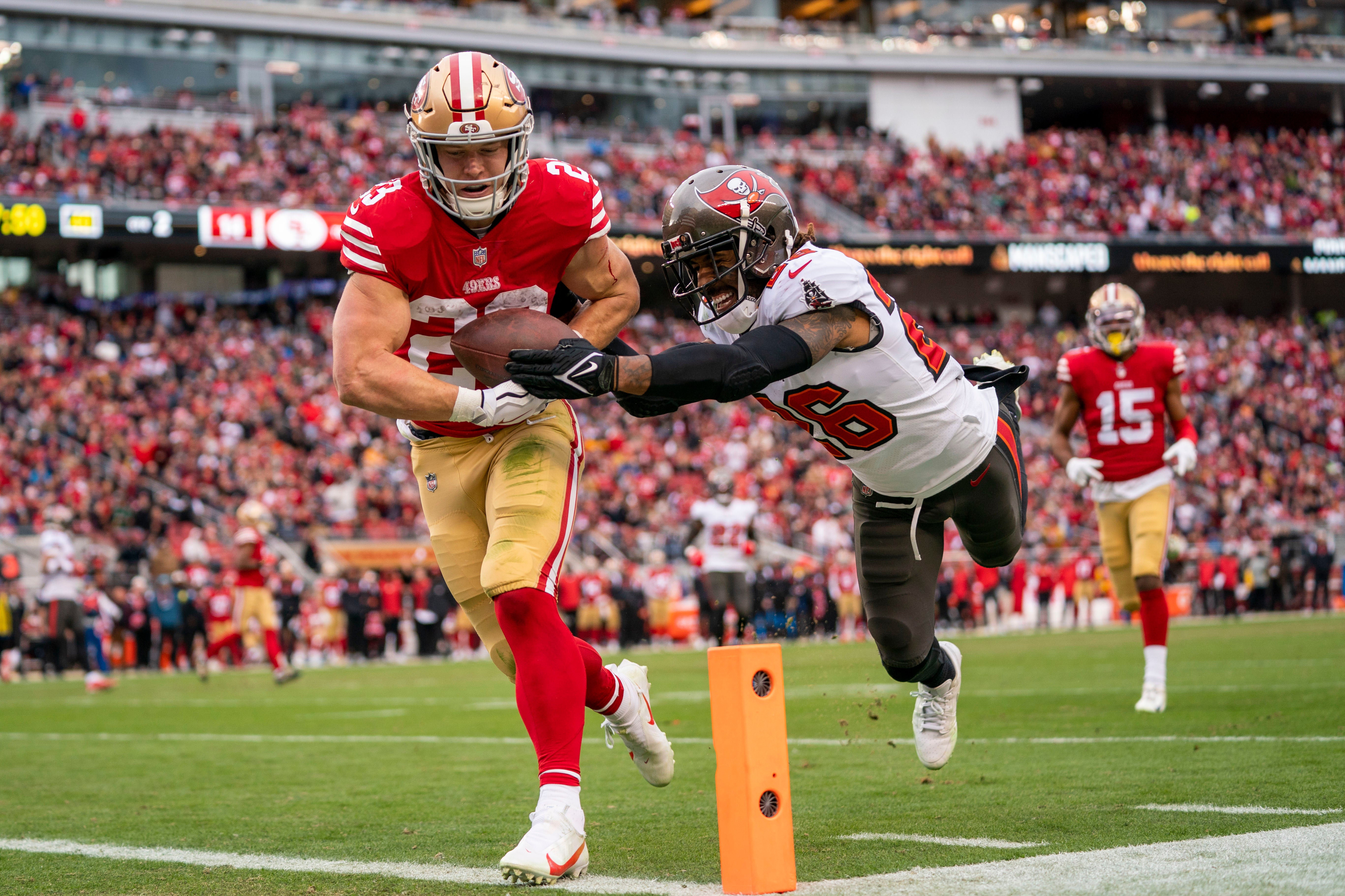 December 11, 2022; Santa Clara, California, USA; San Francisco 49ers running back Christian McCaffrey (23) scores a touchdown against Tampa Bay Buccaneers safety Logan Ryan (26) during the second quarter at Levi's Stadium.