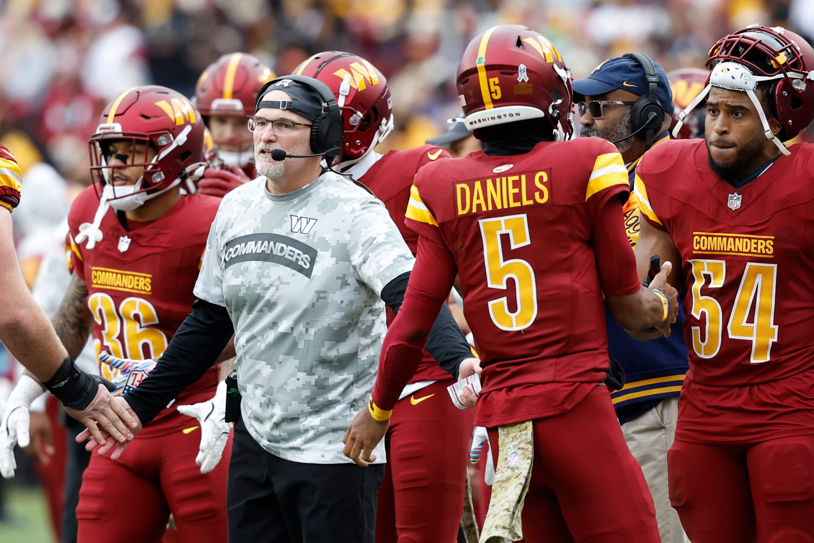 Nov 10, 2024; Landover, Maryland, USA; Washington Commanders head coach Dan Quinn (L) congratulates Commanders quarterback Jayden Daniels (5) after a touchdown drive against the Pittsburgh Steelers during the first half at Northwest Stadium.