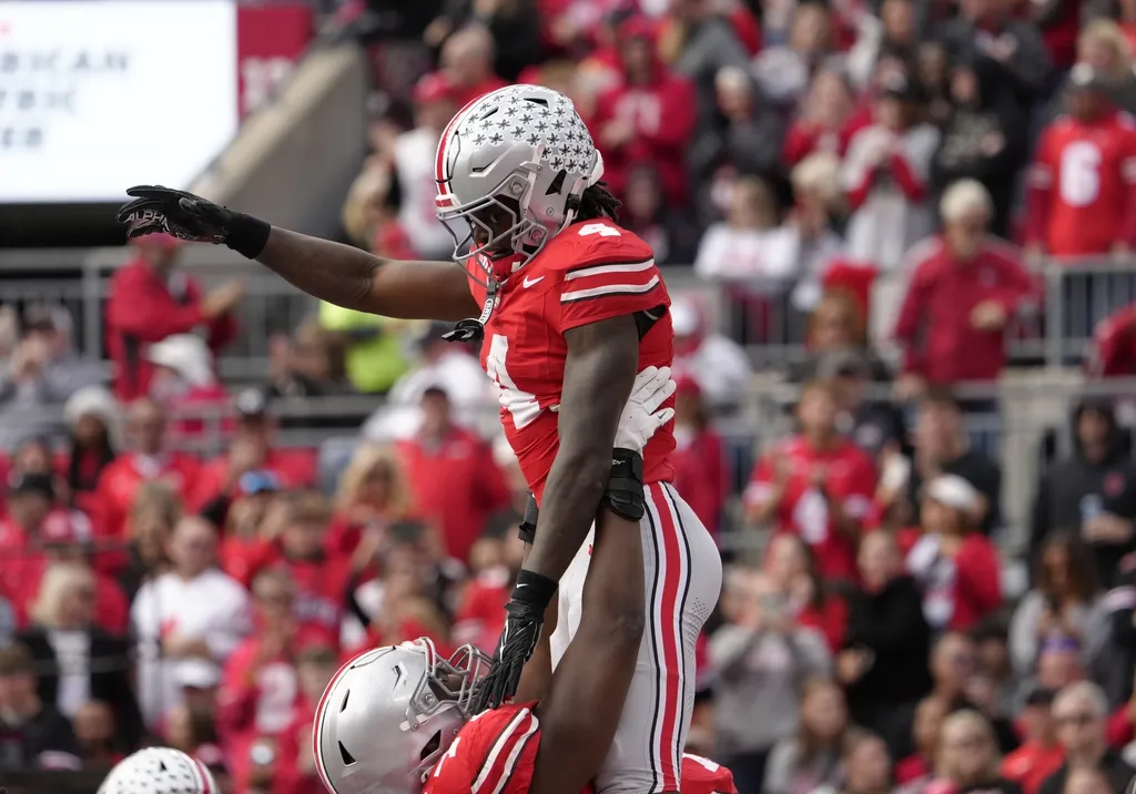 Ohio State Buckeyes wide receiver Jeremiah Smith (4) is hoisted in the air by Ohio State Buckeyes offensive lineman Tegra Tshabola (77) after scoring a touchdown during the first half at Ohio Stadium
