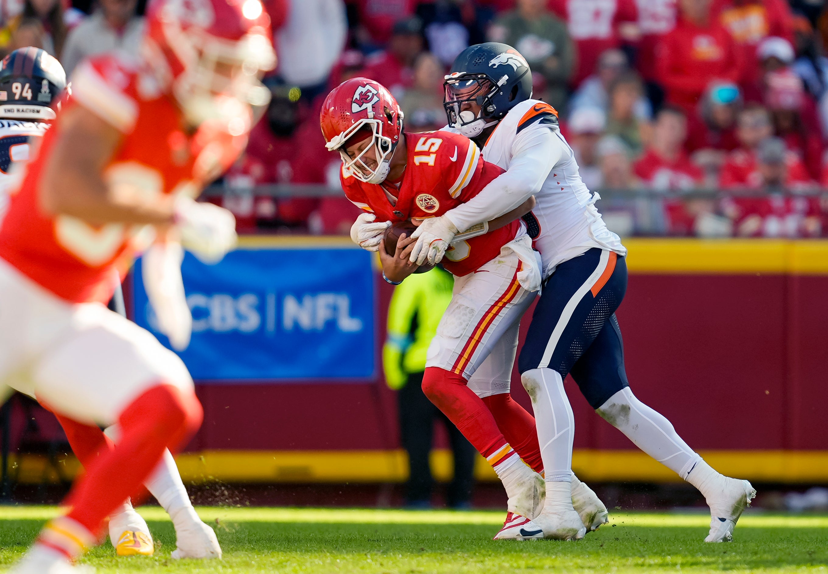 Kansas City Chiefs quarterback Patrick Mahomes (15) is sacked but Denver Broncos linebacker Jonathon Cooper (0) during the second half at GEHA Field at Arrowhead Stadium.