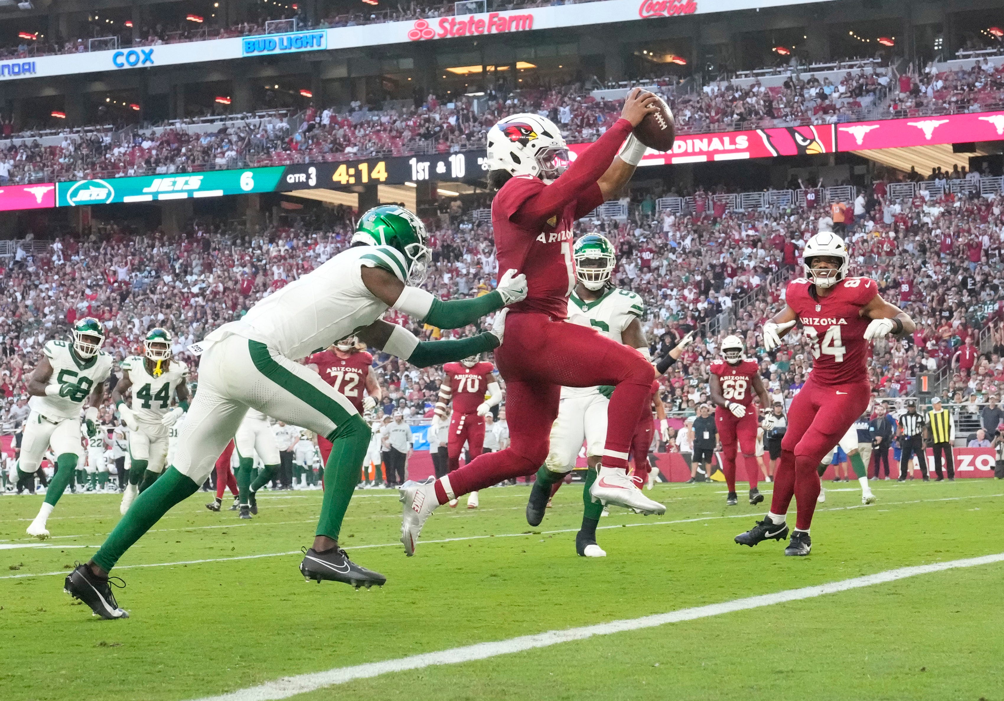Arizona Cardinals quarterback Kyler Murray (1) runs for a touchdown ahead of New York Jets cornerback Sauce Gardner (1) during the third quarter at State Farm Stadium.