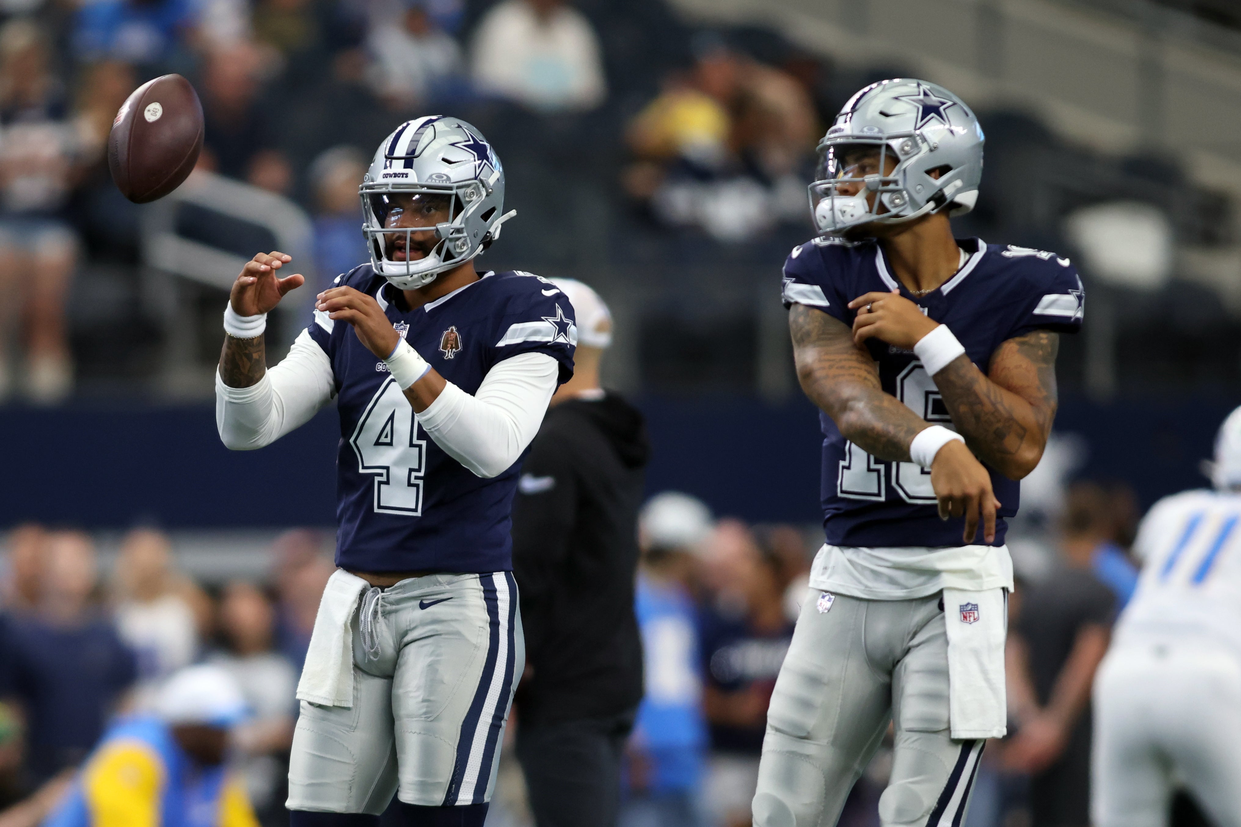 Dallas Cowboys quarterback Dak Prescott (4) and quarterback Trey Lance (19) warm up before the game against the Los Angeles Chargers at AT&T Stadium.