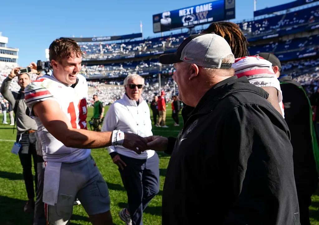 Ohio State Buckeyes offensive coordinator Chip Kelly celebrates with quarterback Will Howard (18) following the NCAA football game against the Penn State Nittany Lions at Beaver Stadium in University