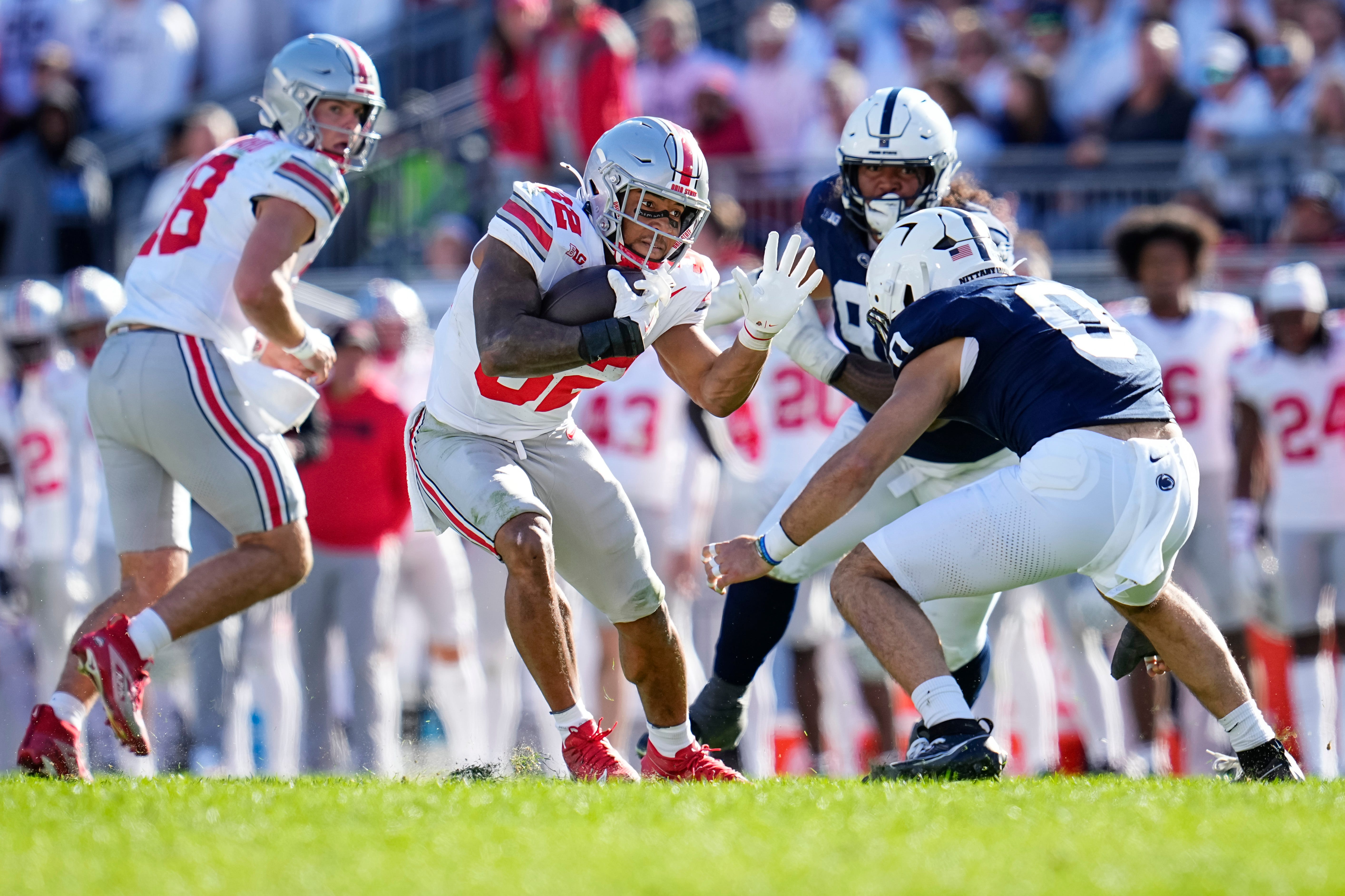 Ohio State Buckeyes running back TreVeyon Henderson (32) tries to elude Penn State Nittany Lions linebacker Dominic DeLuca (0) during the NCAA football game at Beaver Stadium in University Park, Pa. on Monday, Nov. 4, 2024. Ohio State won 20-13.