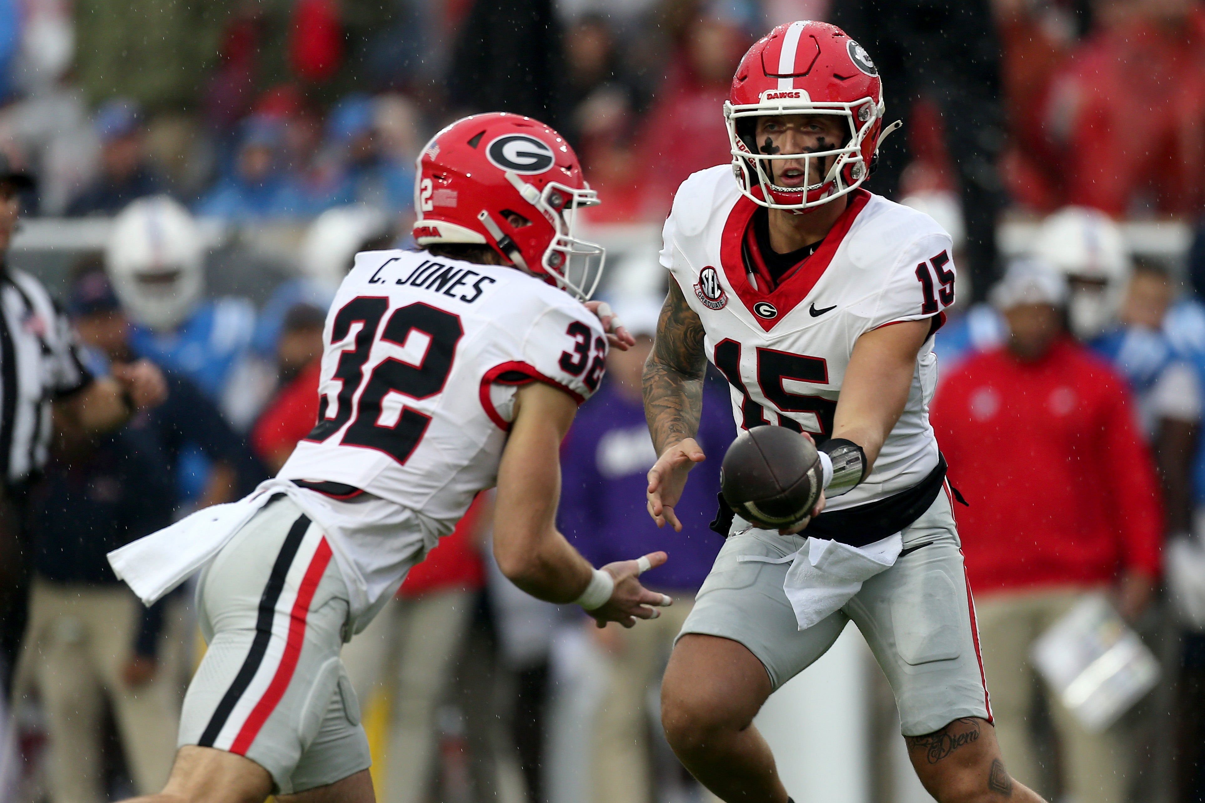 Georgia Bulldogs quarterback Carson Beck (15) hands the ball off to running back Cash Jones (32) during the first half against the Mississippi Rebels at Vaught-Hemingway Stadium.