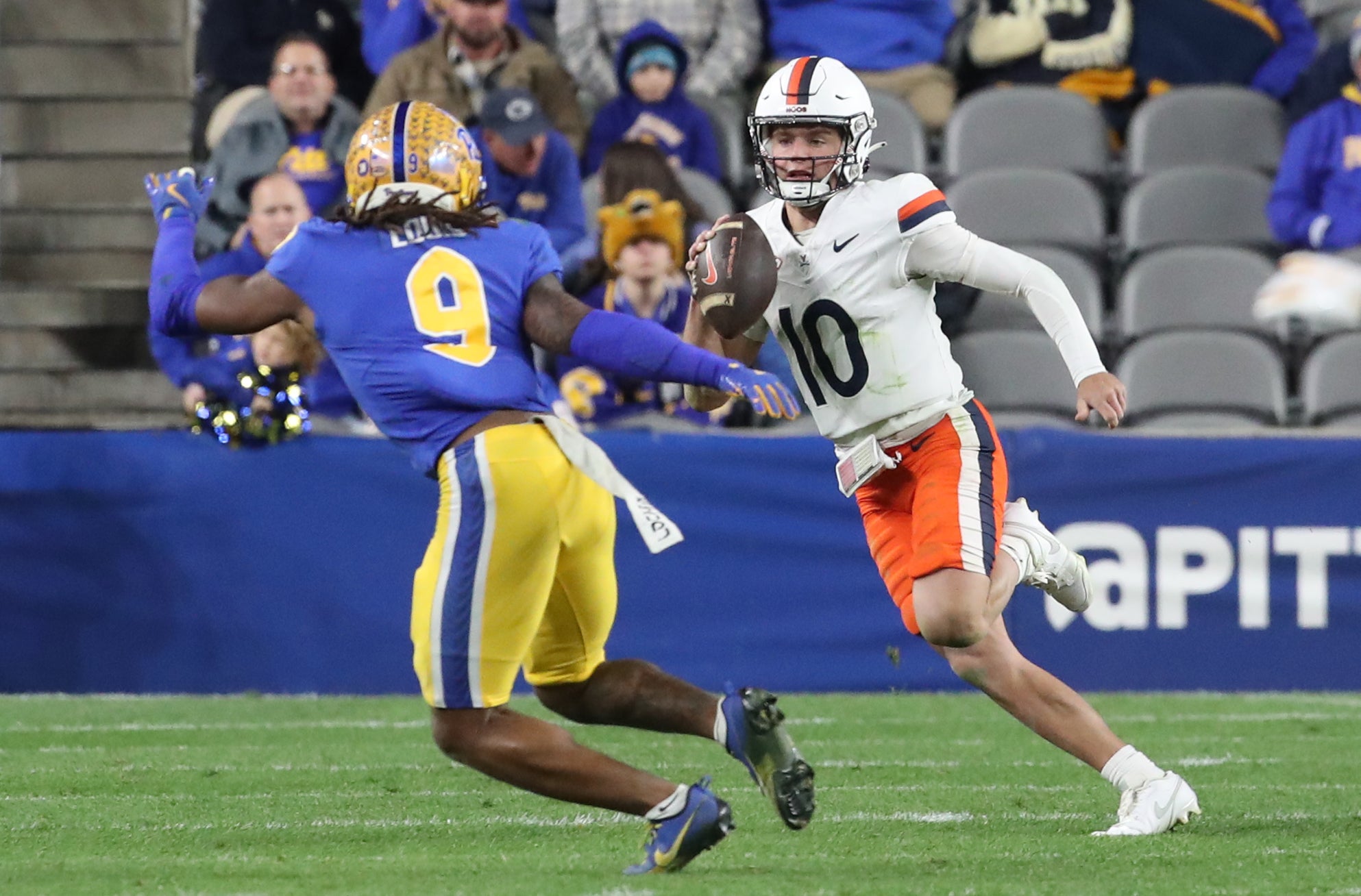 Virginia Cavaliers quarterback Anthony Colandrea (10) runs the ball against Pittsburgh Panthers linebacker Kyle Louis (9) during the third quarter at Acrisure Stadium.