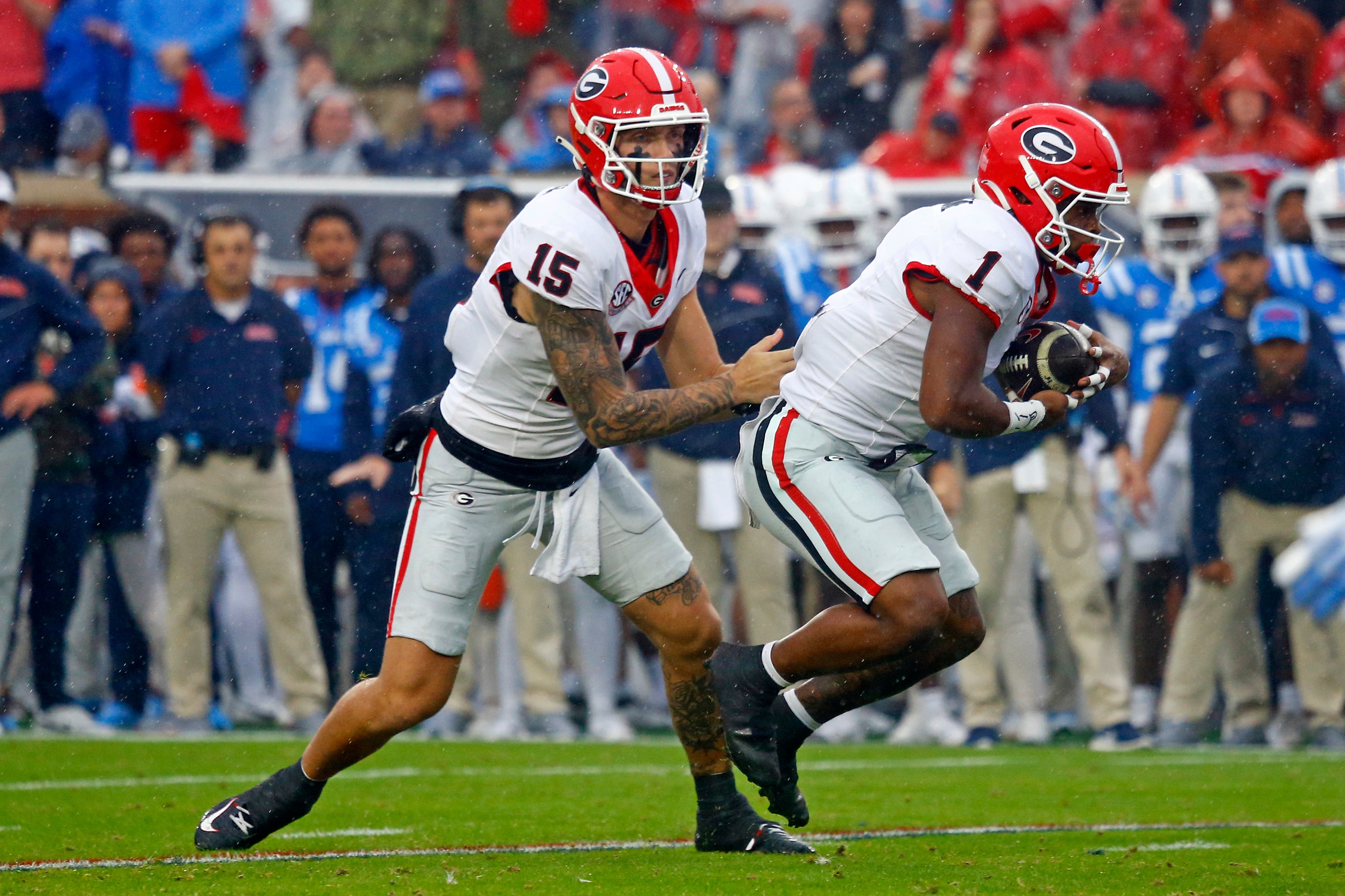 Georgia Bulldogs quarterback Carson Beck (15) hands the ball off to running back Trevor Etienne (1) during the first half against the Mississippi Rebels at Vaught-Hemingway Stadium.