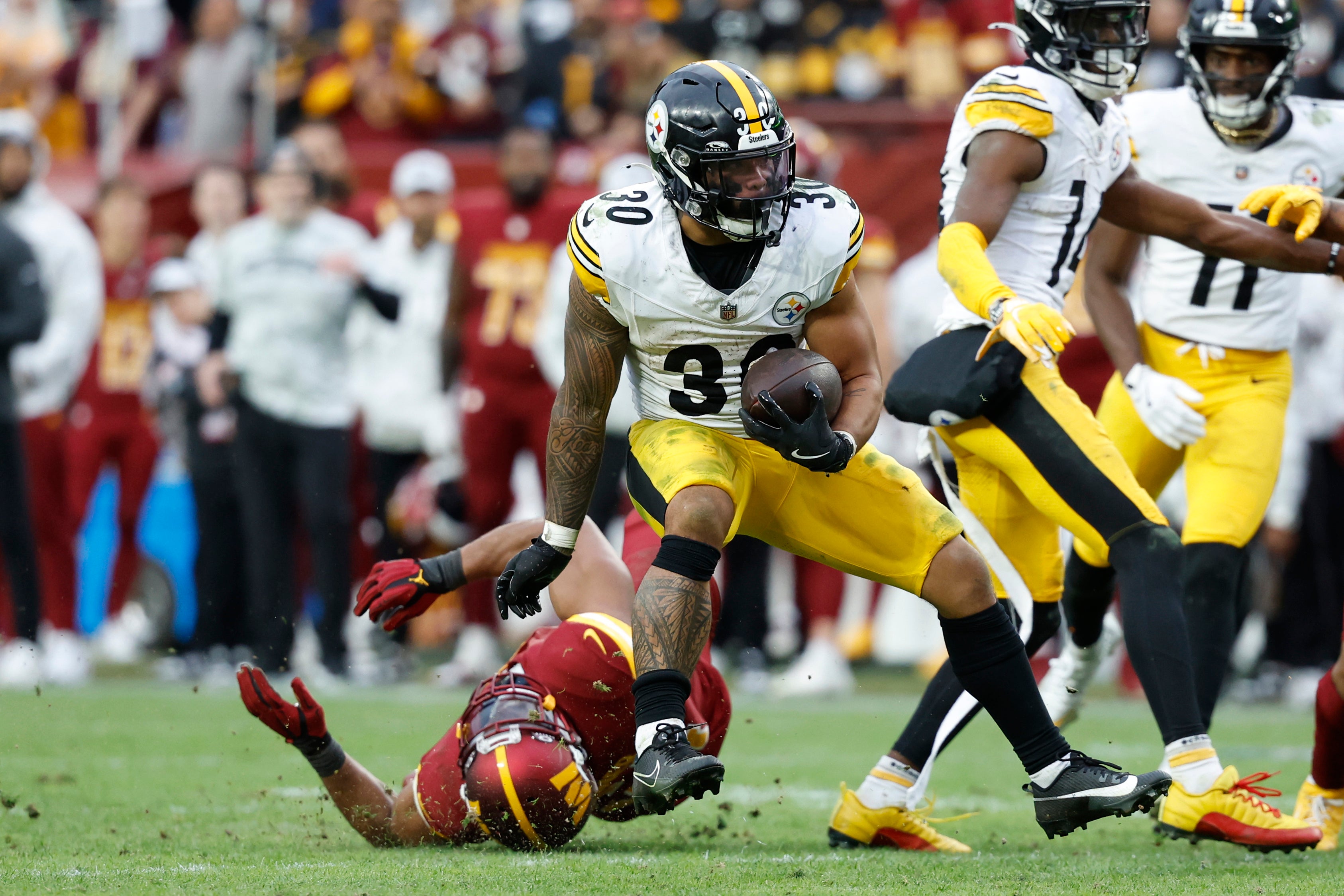Nov 10, 2024; Landover, Maryland, USA; Pittsburgh Steelers running back Jaylen Warren (30) carries the ball past Washington Commanders linebacker Bobby Wagner (54) during the second half at Northwest Stadium. Mandatory Credit: Geoff Burke-Imagn Images