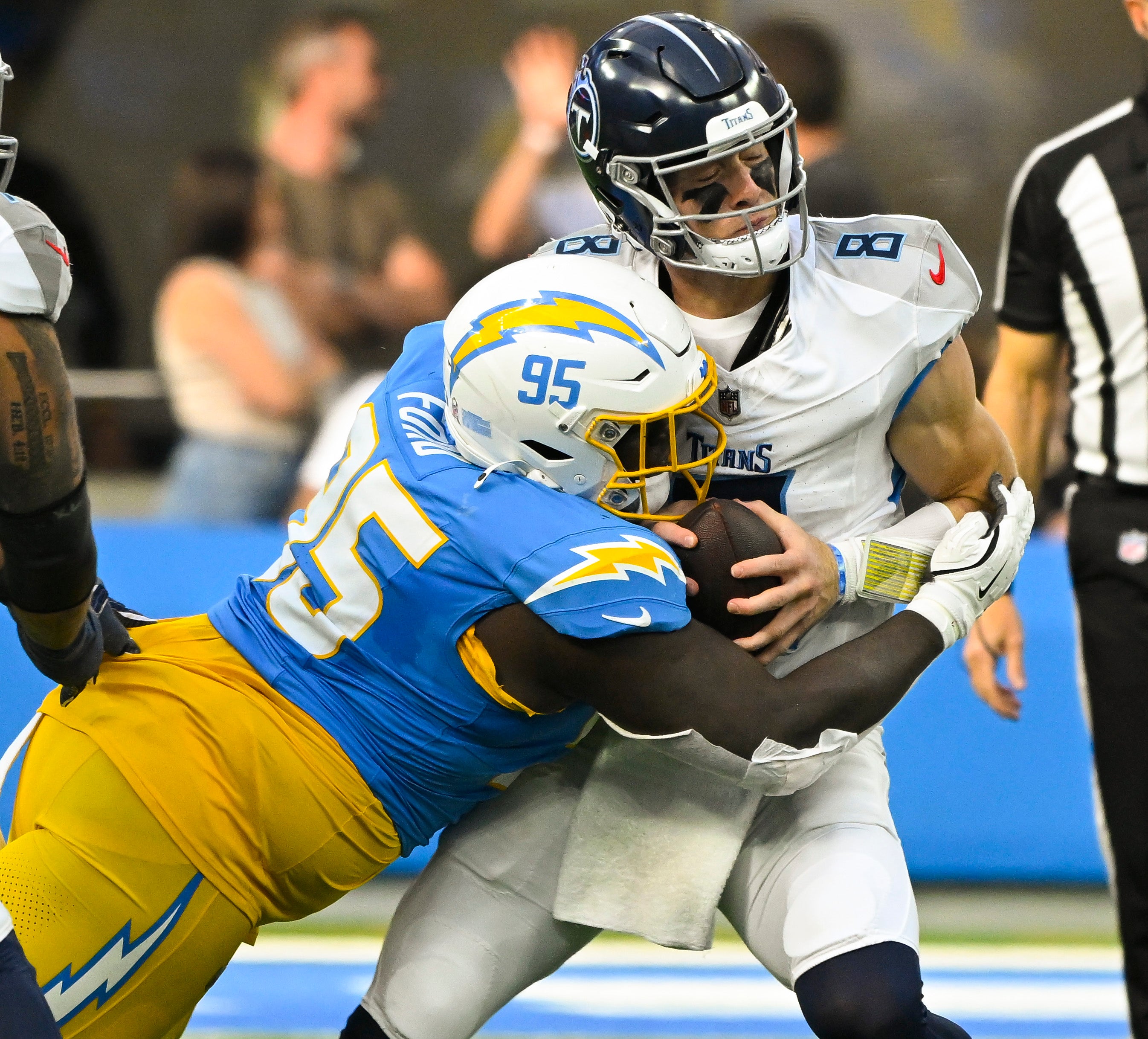 Los Angeles Chargers defensive tackle Poona Ford (95) sacks Tennessee Titans quarterback Will Levis (8) during the second quarter at SoFi Stadium.