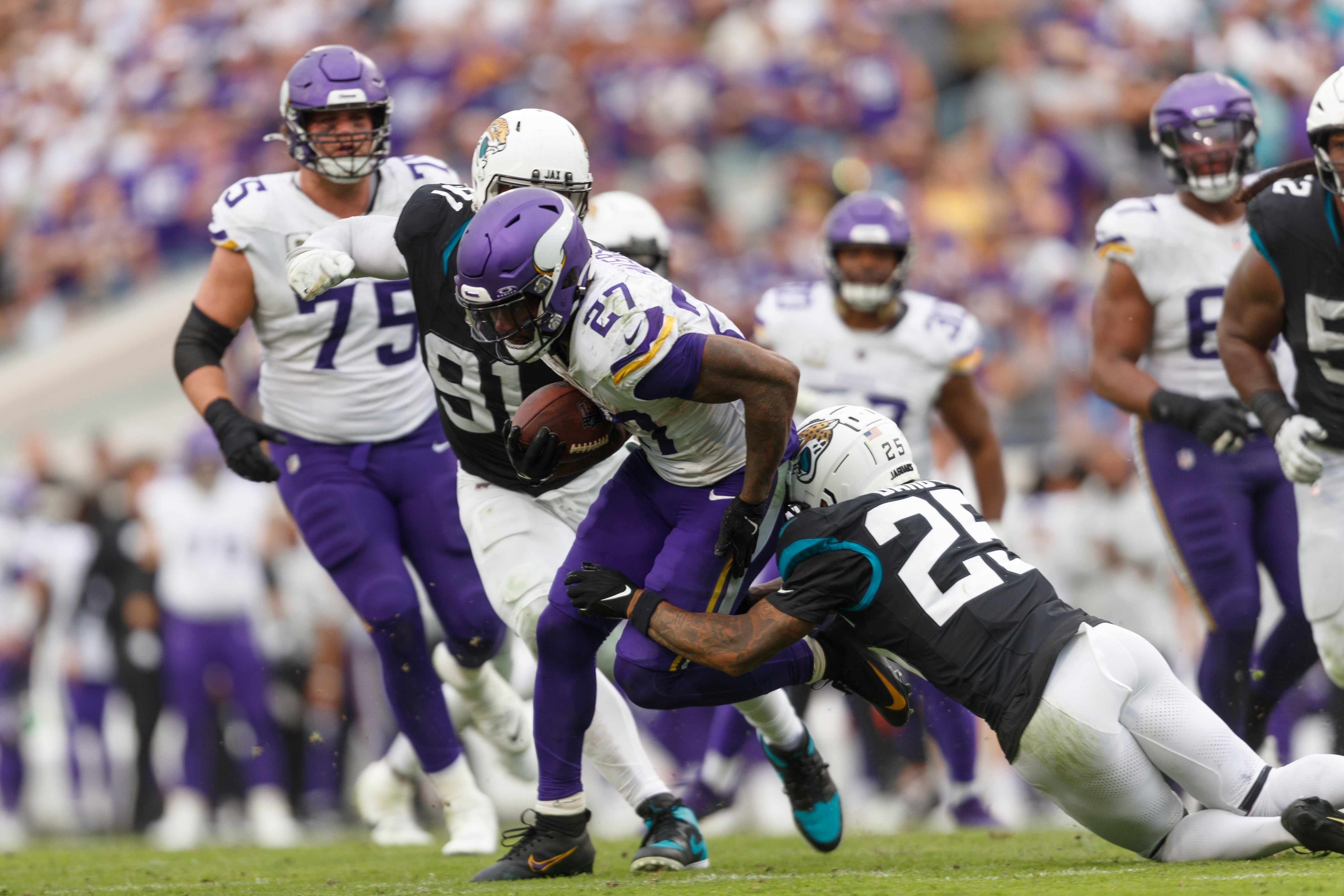 Nov 10, 2024; Jacksonville, Florida, USA; Jacksonville Jaguars cornerback Ronald Darby (25) tackles Minnesota Vikings running back Cam Akers (27) during the fourth quarter at EverBank Stadium.