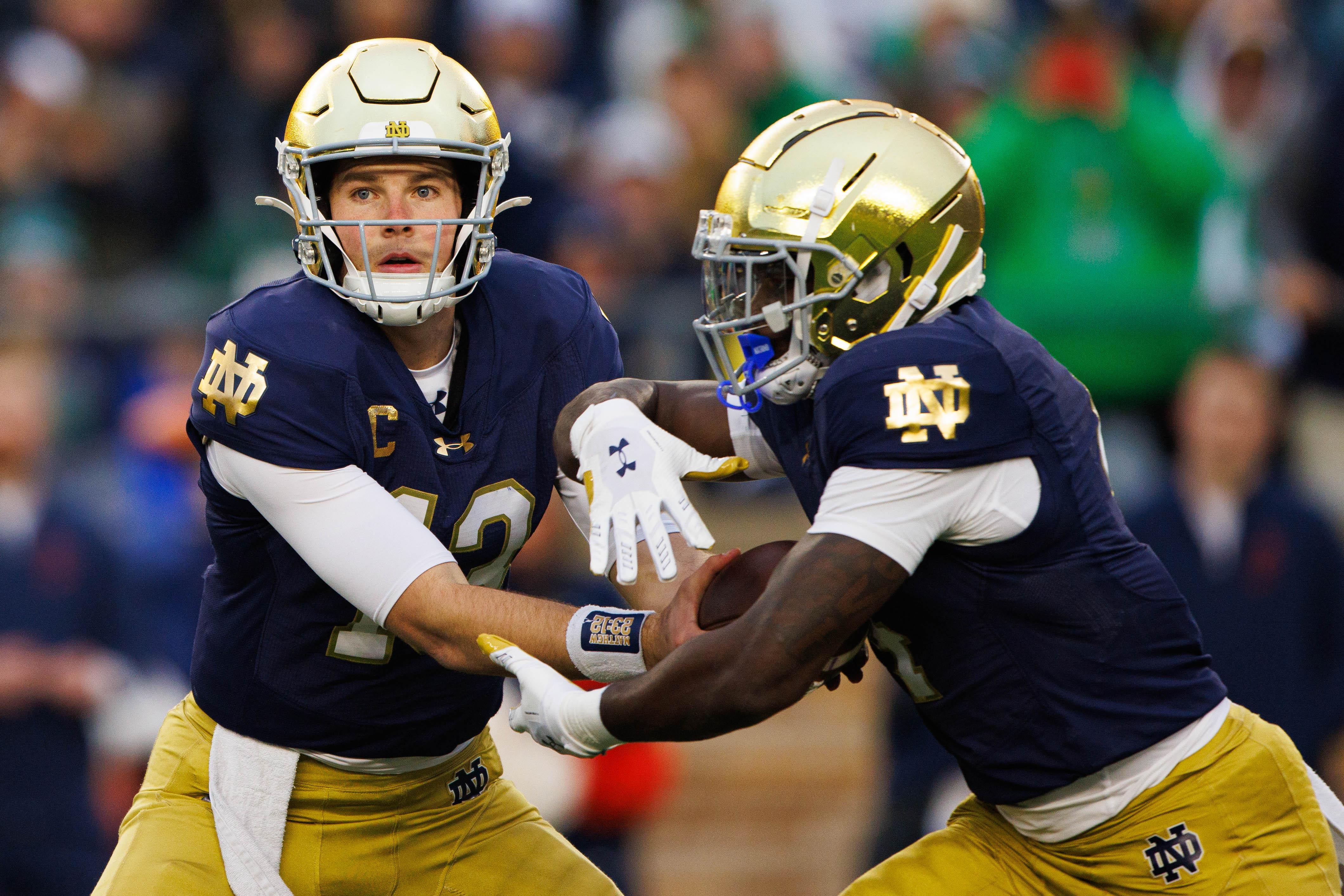 Notre Dame quarterback Riley Leonard (13) hands the ball off to running back Jeremiyah Love (4) during a NCAA college football game against Virginia at Notre Dame Stadium on Saturday, Nov. 16, 2024, in South Bend.
