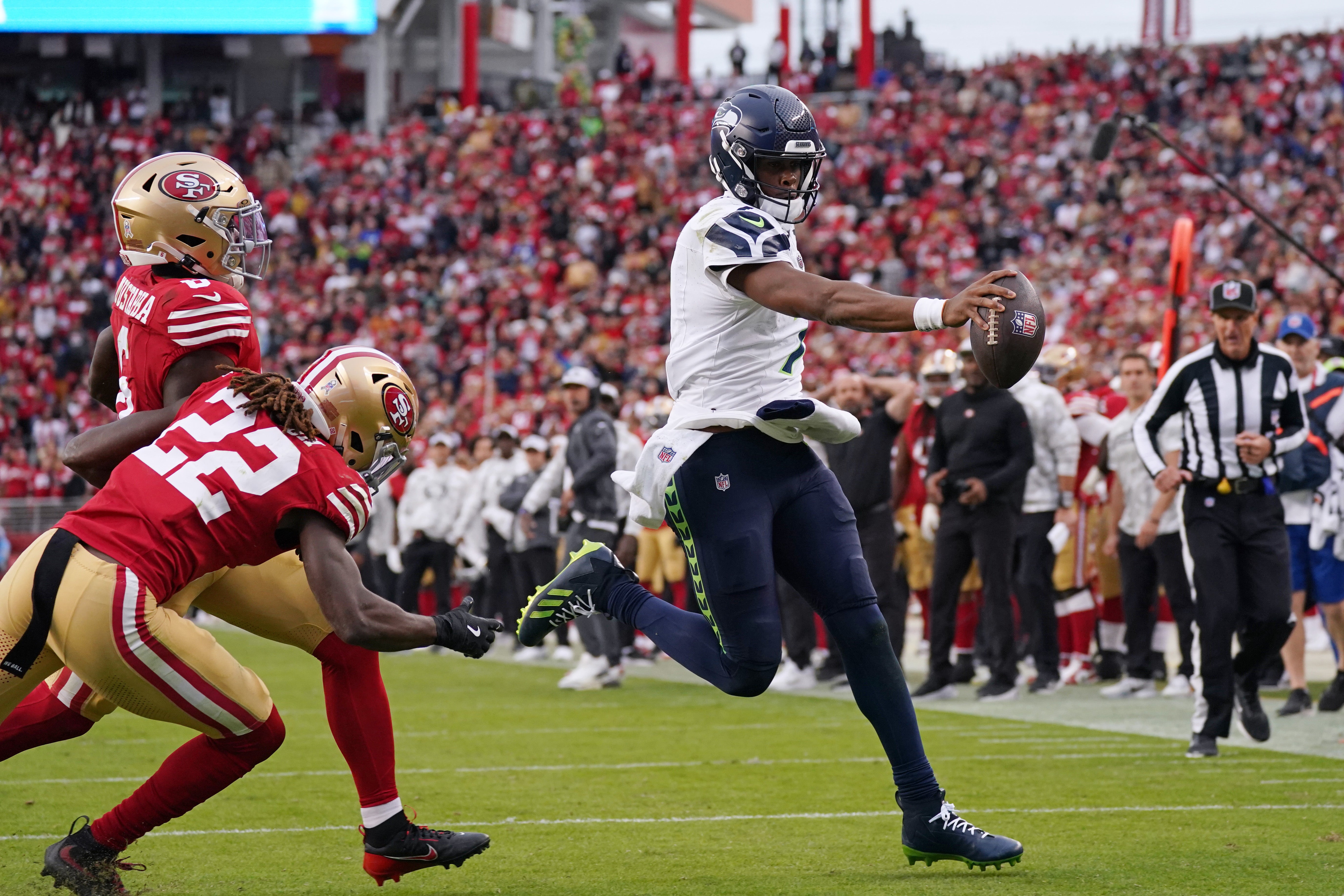 Seattle Seahawks quarterback Geno Smith (7) scores a rushing touchdown past San Francisco 49ers cornerback Isaac Yiadom (22) to win the game in the fourth quarter at Levi's Stadium.