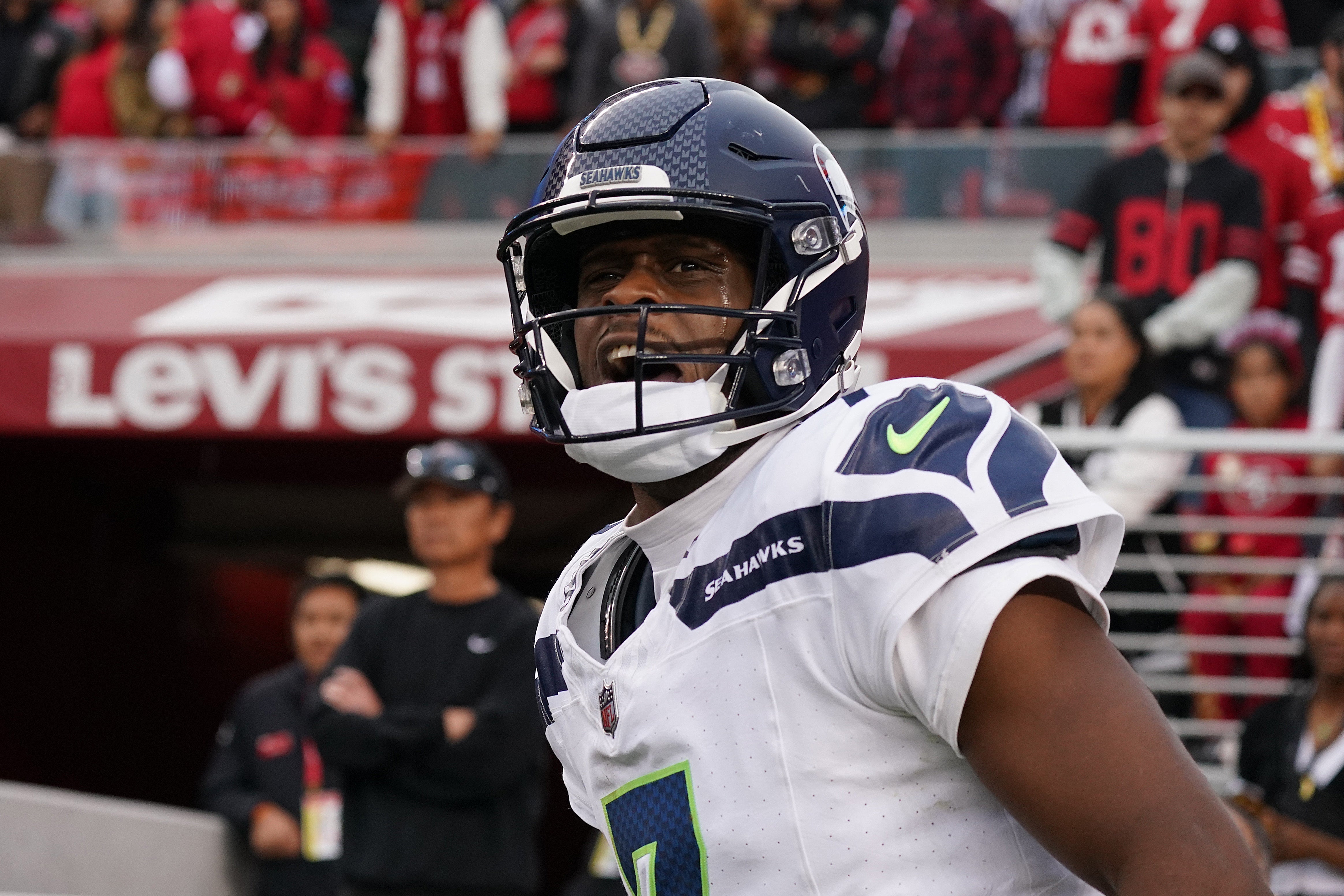 Nov 17, 2024; Santa Clara, California, USA; Seattle Seahawks quarterback Geno Smith (7) celebrates after scoring a rushing touchdown past San Francisco 49ers cornerback Isaac Yiadom (22) to win the game in the fourth quarter at Levi's Stadium.